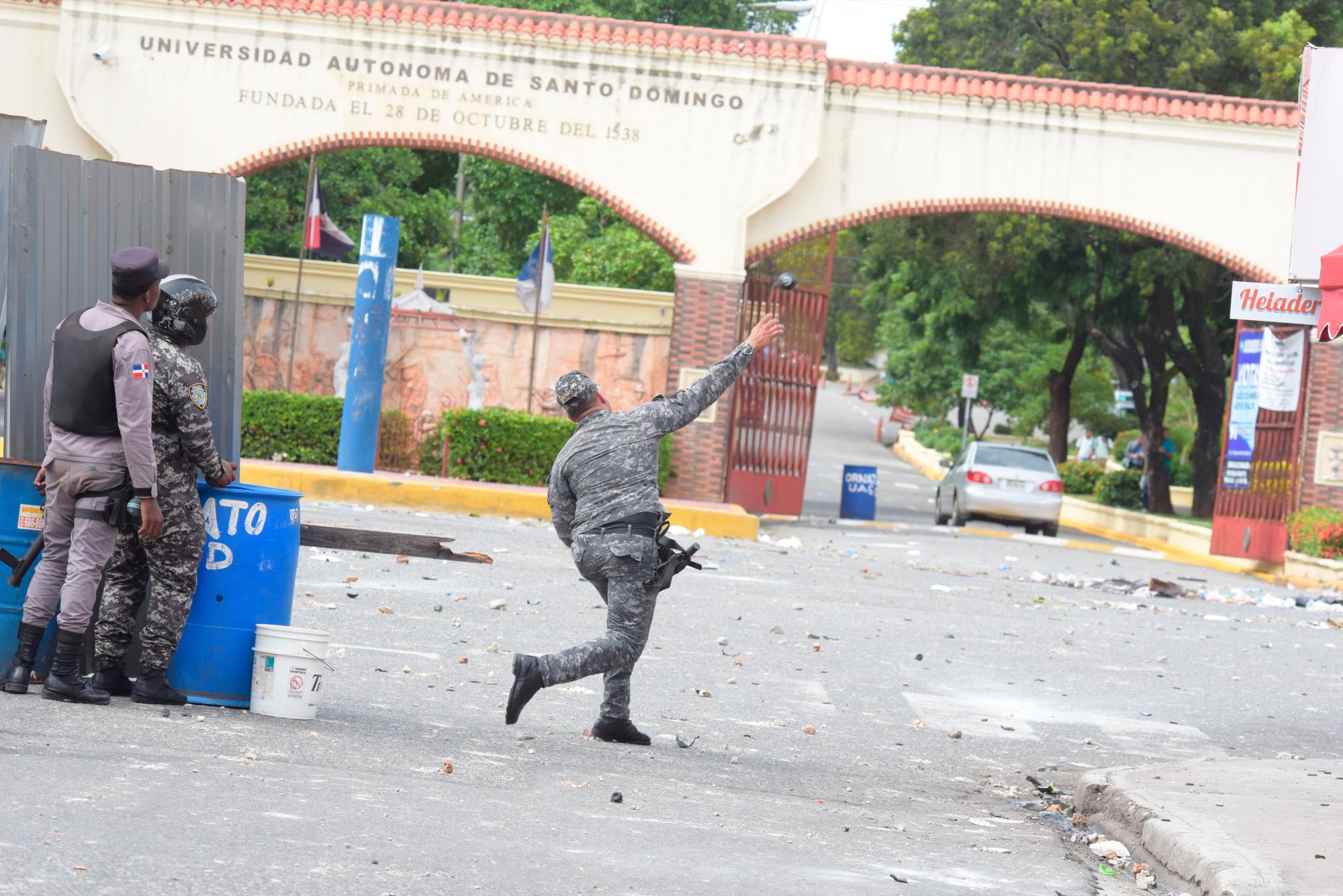 Un policia arroja una bomba lacrimógena en frente a una de las puerta de entrada a la UASD, el día 8 de octubre de 2018.