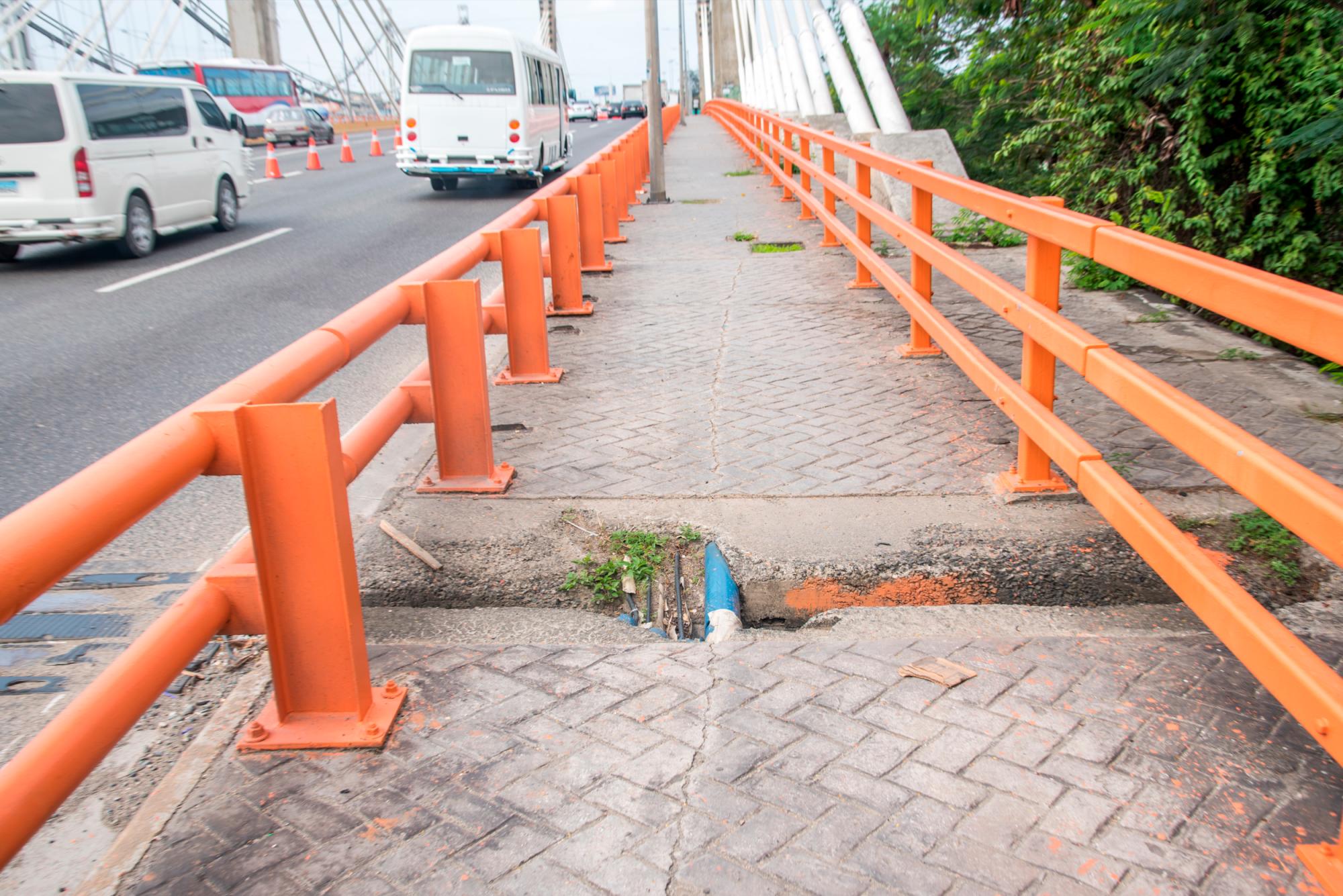 Los peatones también cruzan el puente con el peligro de caer en una de las zanjas.