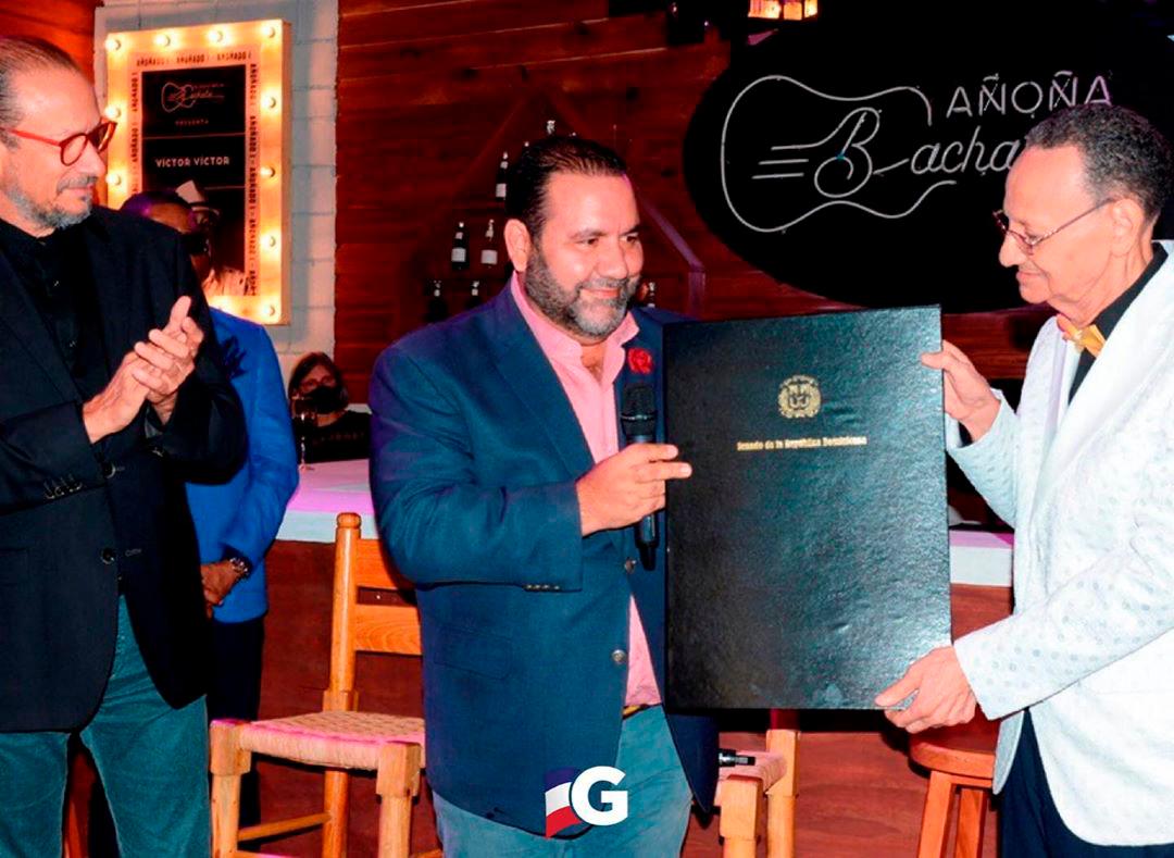 El maestro Luis Segura recibe el reconocimiento del Senado de la República de manos del senador Ramón Rogelio Genao y el exembajador José Antonio Rodríguez.