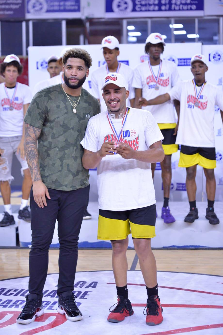 El jugador de baloncesto, Brandone Francis entrega el trofeo de Jugador Más Valioso a Yeison Rivera.