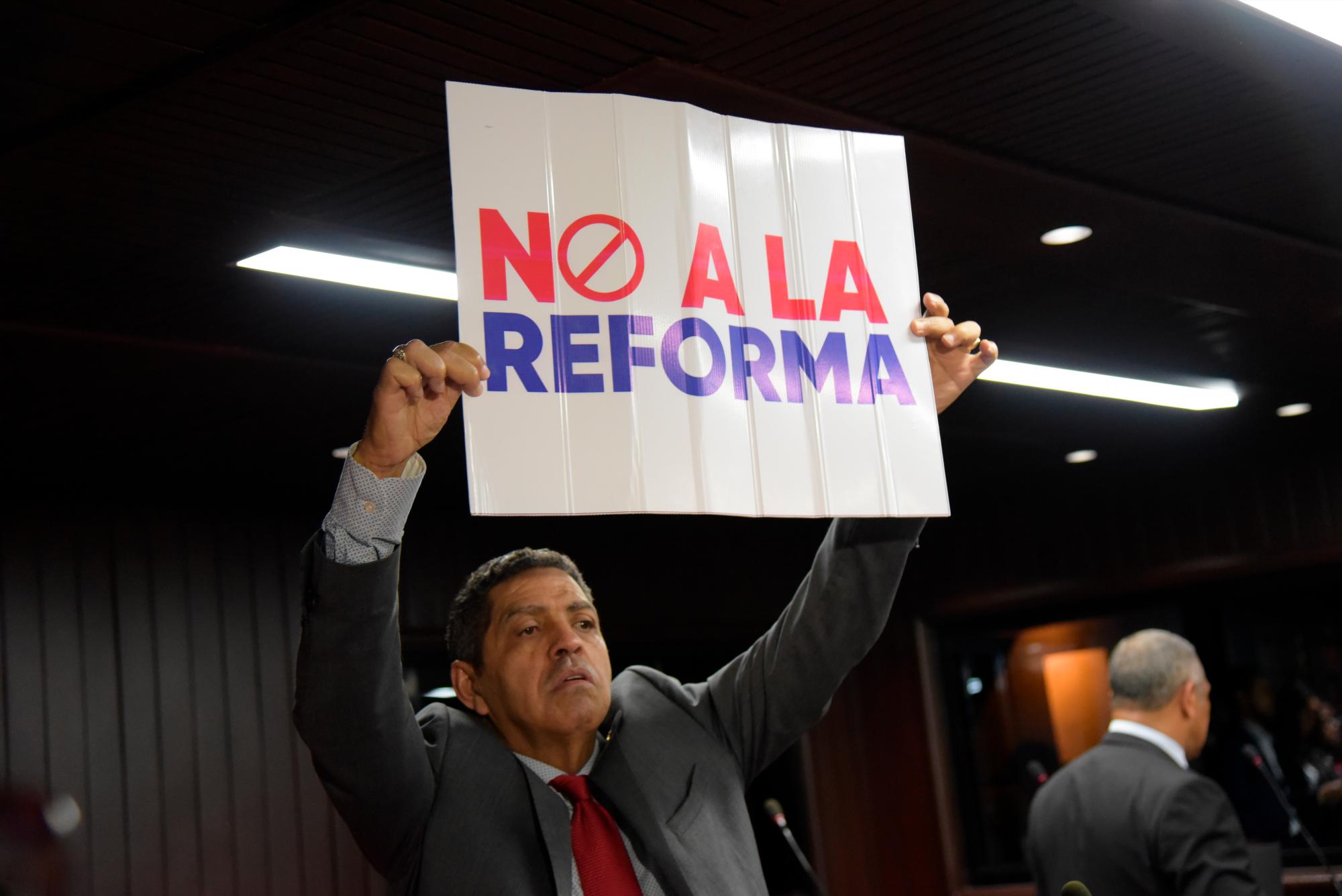 El diputado del PRM, Francisco Paulino, levanta un cartel con no a la reforma durante la sesión de este viernes 12 de julio de 2019.