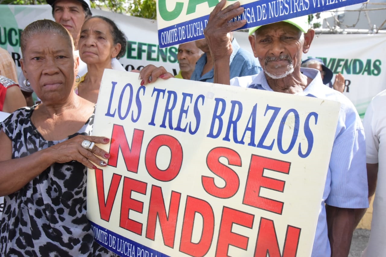 Los residentes de Los Tres Brazos mientras demandaban este martes el inicio del proceso de deslinde de los solares para titular los terrenos de los moradores de ese sector.