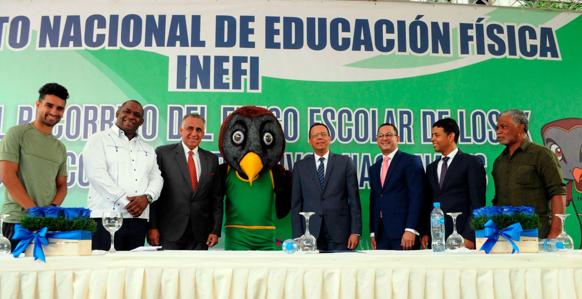 De izquierda a derecha, el atleta Luguelin Santos, el profesor Nelson Acevedo, el presidente del Comité Olímpico Dominicano, Luisín Mejía; la mascota de los Juegos -Hobu- el ministro de Educación, Antonio Peña; el director del Instituto Nacional de Educación Física, Jorge Minaya; Jesús Soriano y el profesor Isaac Ogando.