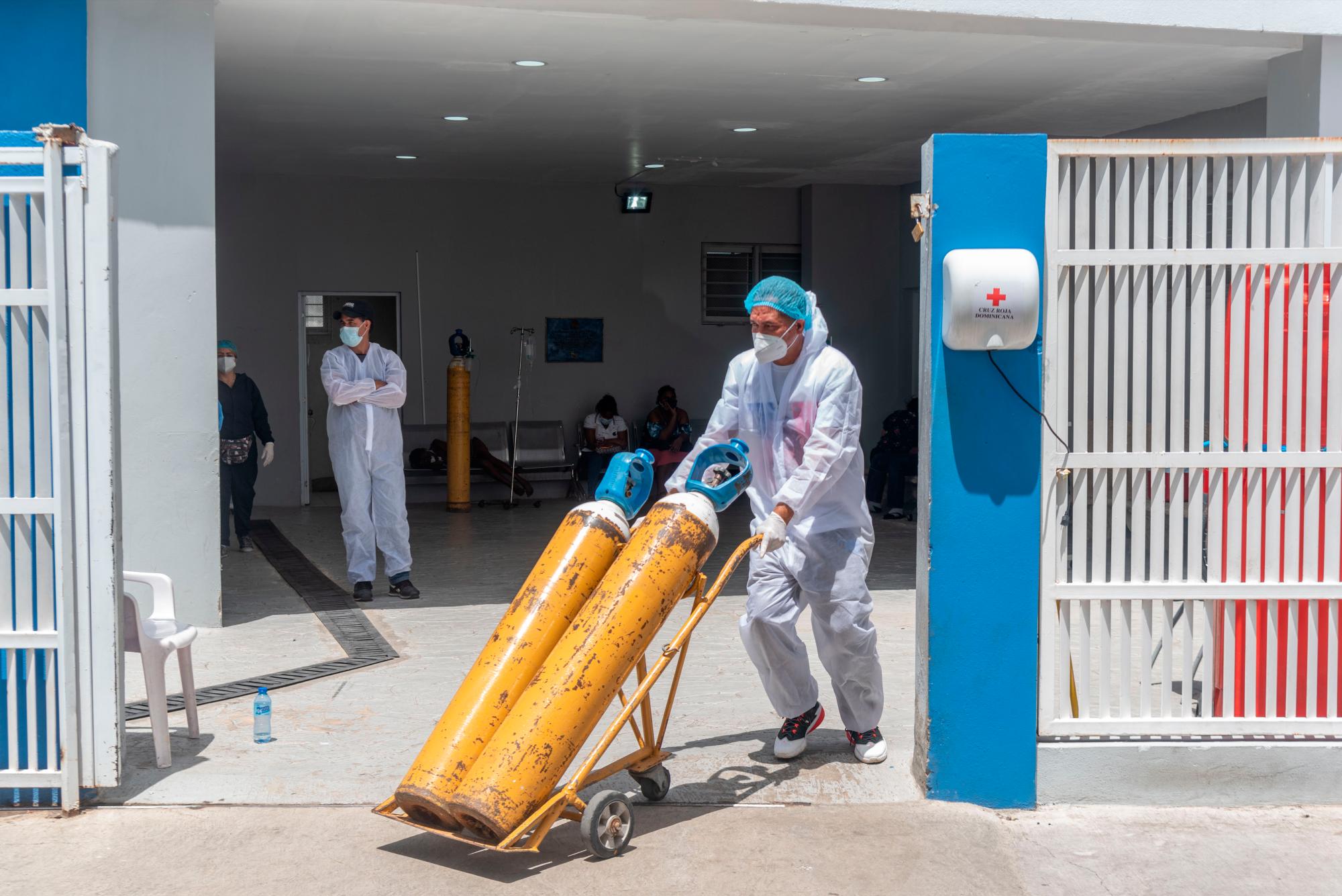Personal de salud cambia tanque de oxígeno. 