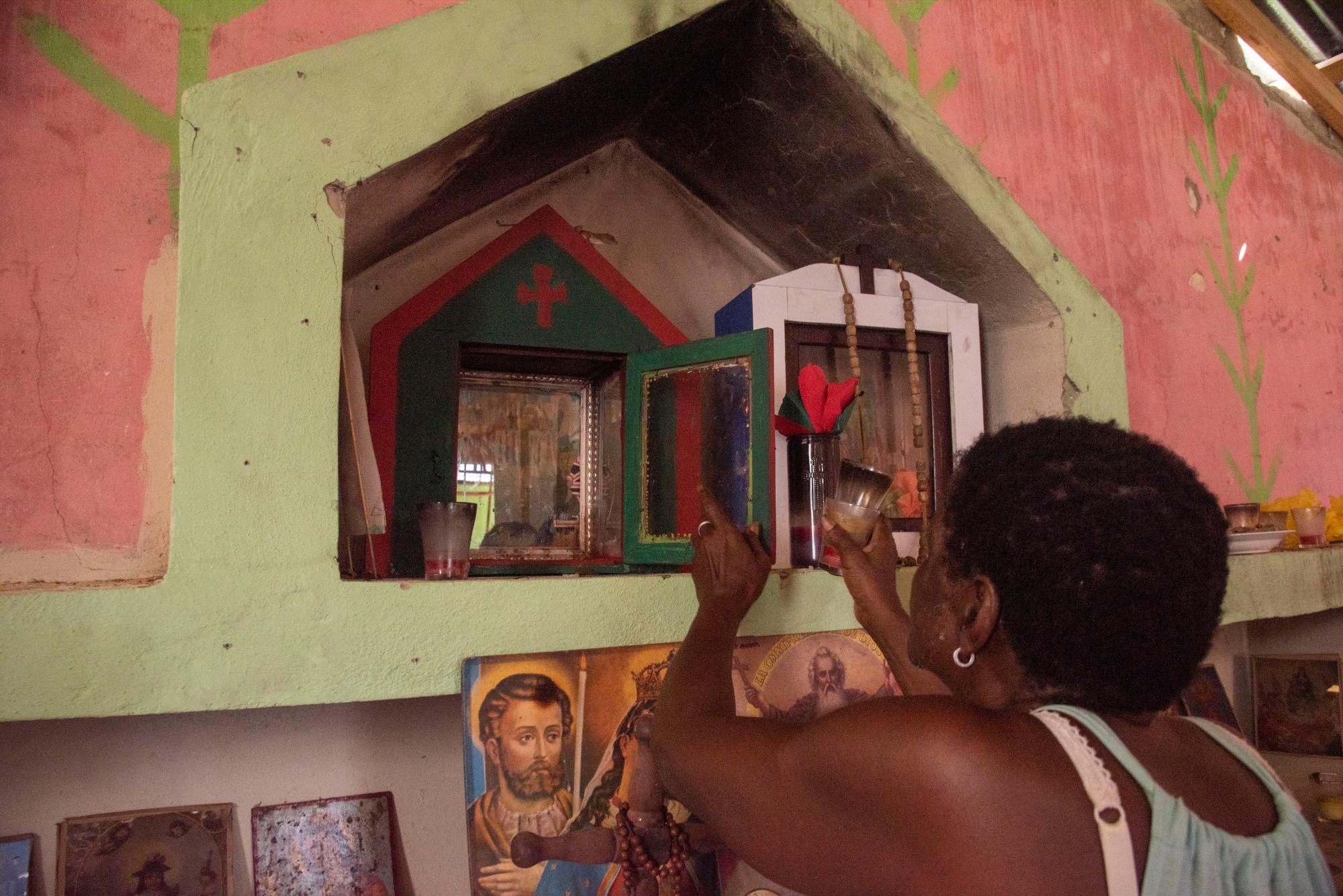 La gente lleva velas y velones a los santos.