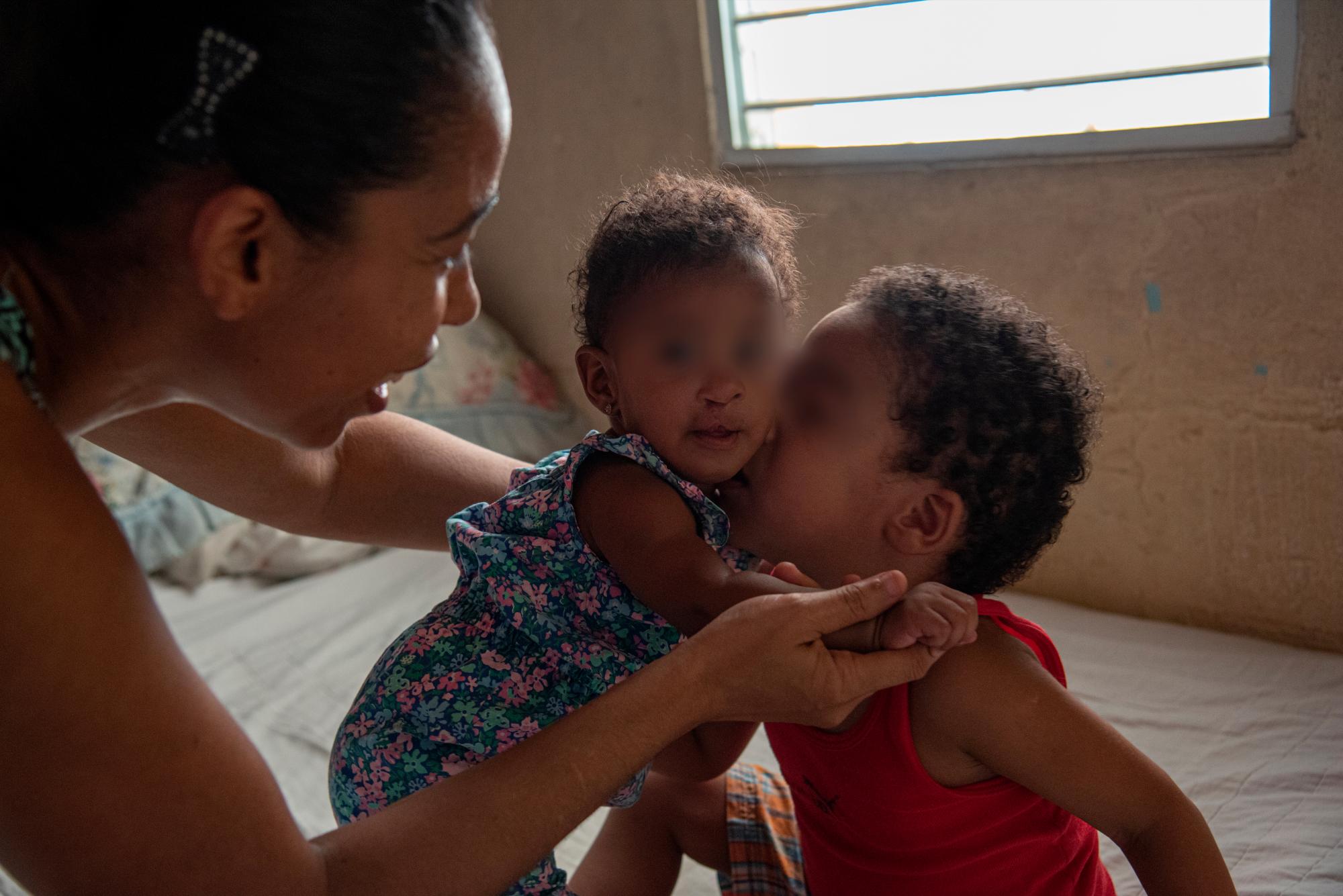 El primer hijo de Yohavel Bidó besa a su hermanita, quien espera por una próxima cirugía reconstructiva.