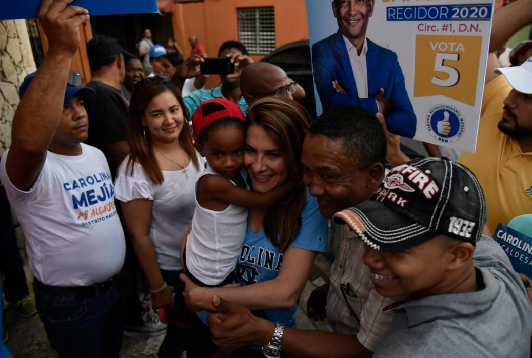 Miembros de una familia se toman fotos con Carolina Mejía. 