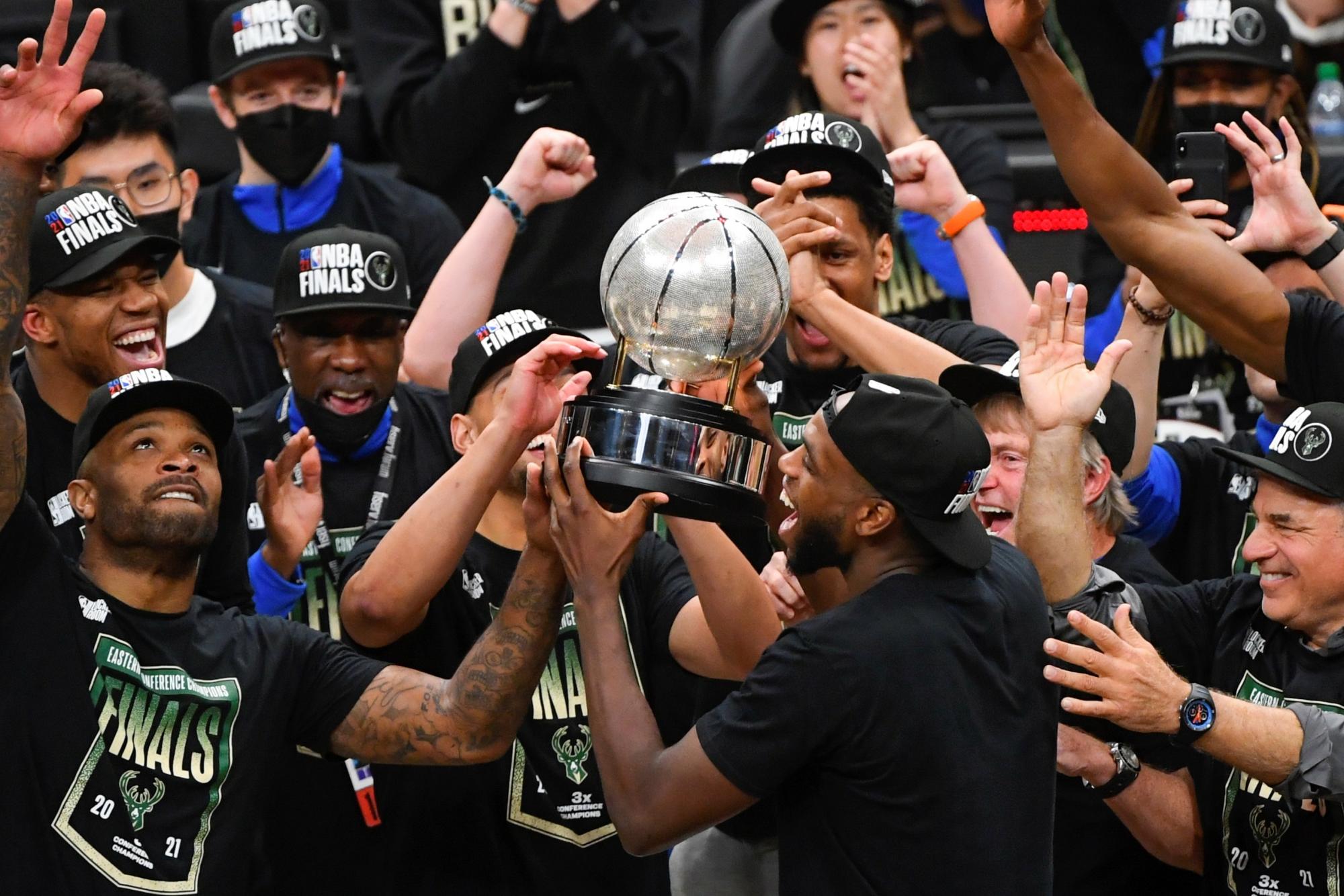 El alero de los Milwaukee Bucks Khris Middleton (CR) levanta el trofeo mientras él y sus compañeros celebran ganar el título tras el sexto partido de la serie de playoffs de las Finales de la Conferencia Este de la NBA entre los Milwaukee Bucks y los Atlanta Hawks en State Farm Arena en Atlanta, el 3 de julio de 2021. (EFE/EPA/John Amis Shutterstock)