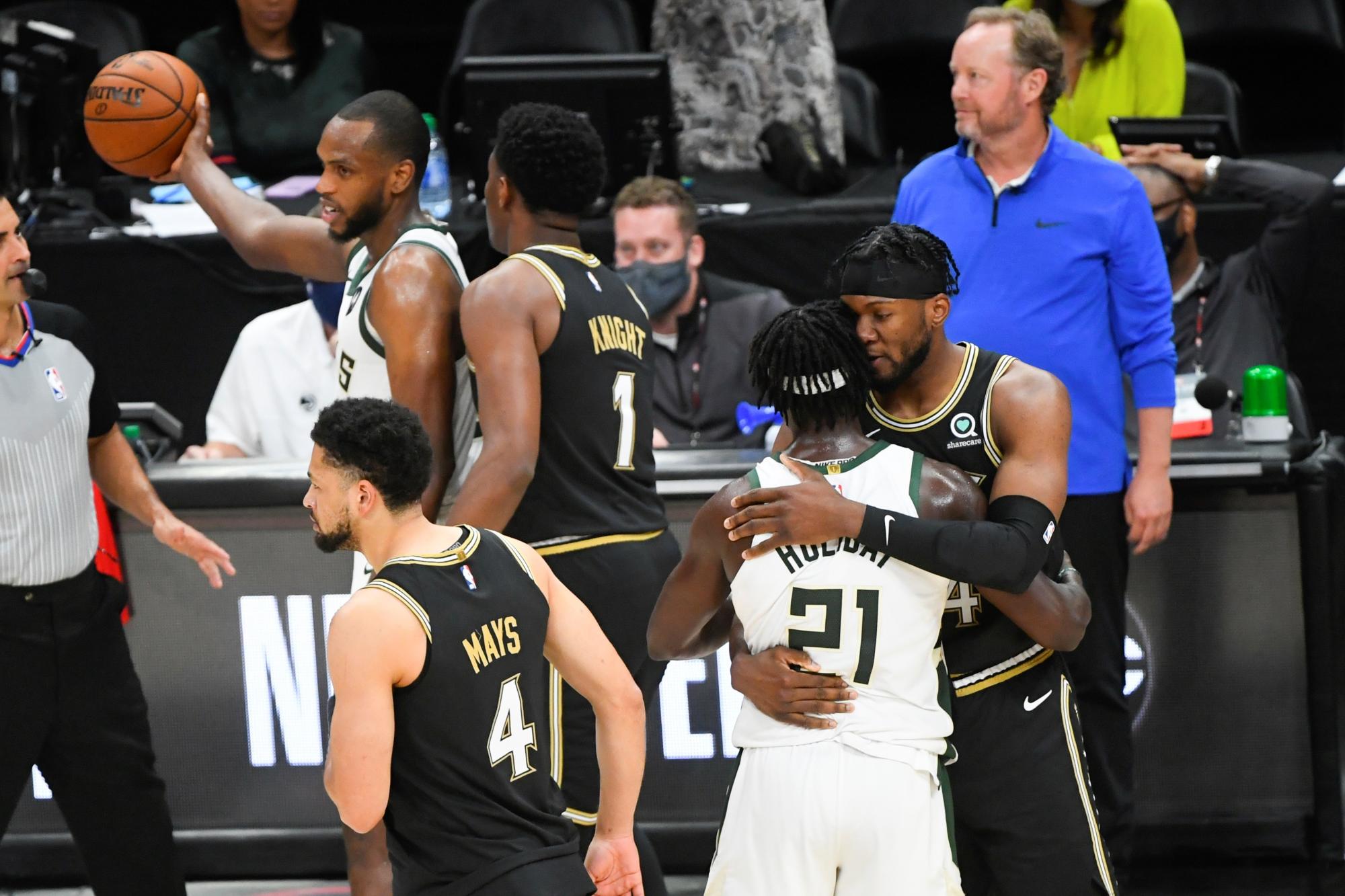El escolta de los Milwaukee Bucks Jrue Holiday (2do de la derecha) es felicitado por el delantero de los Atlanta Hawks Bruno Fernando (derecha) de Angola al concluir el sexto juego de la serie de playoffs de las Finales de la Conferencia Este de la NBA entre los Milwaukee Bucks y los Atlanta Hawks en State Farm Arena en Atlanta, Georgia, Estados Unidos, 3 de julio de 2021. (EFE/John Amis)