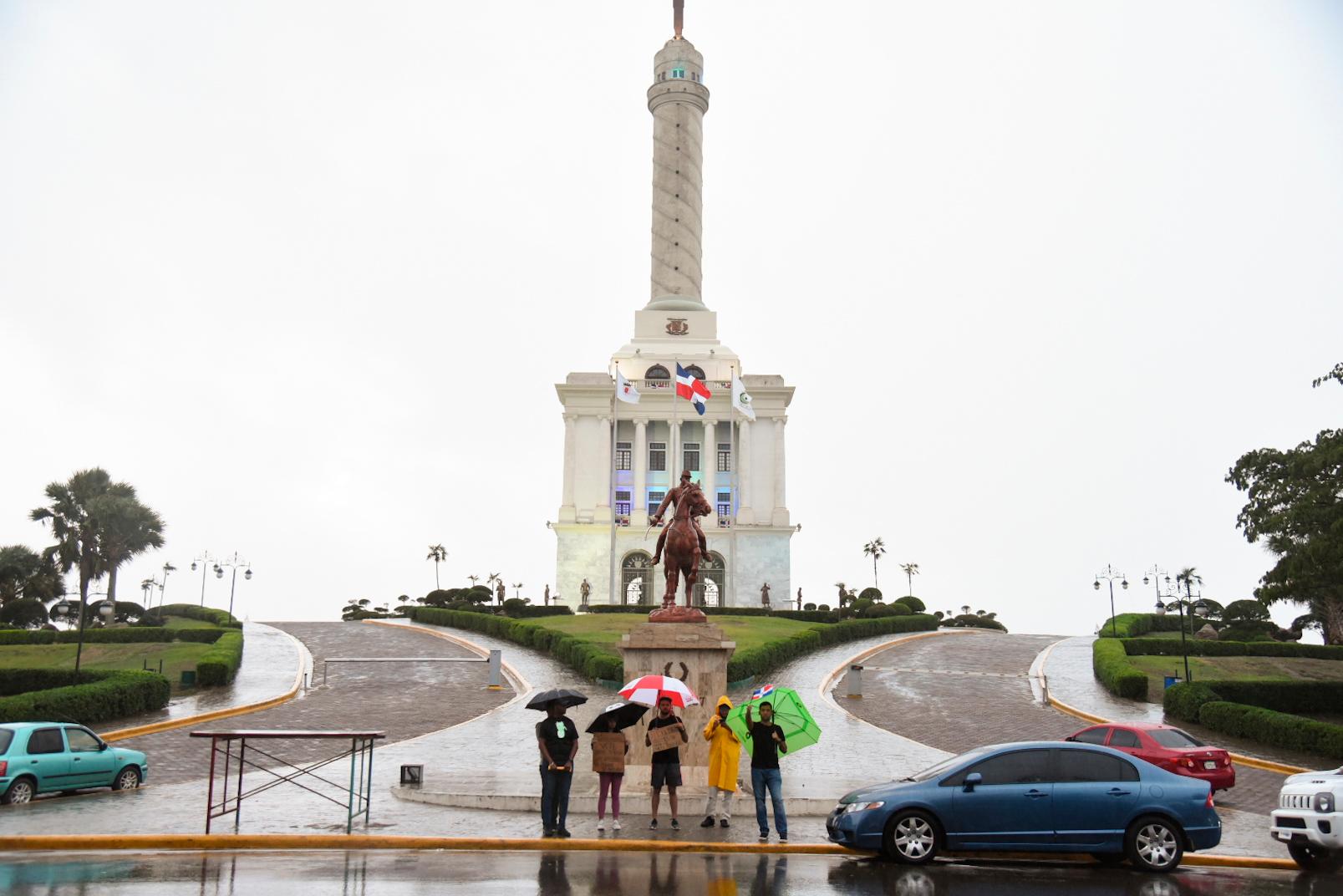 Los seis manifestantes que se reunieron la tarde de este lunes en el Monumento a los Héroes de la Restauración en Santiago.