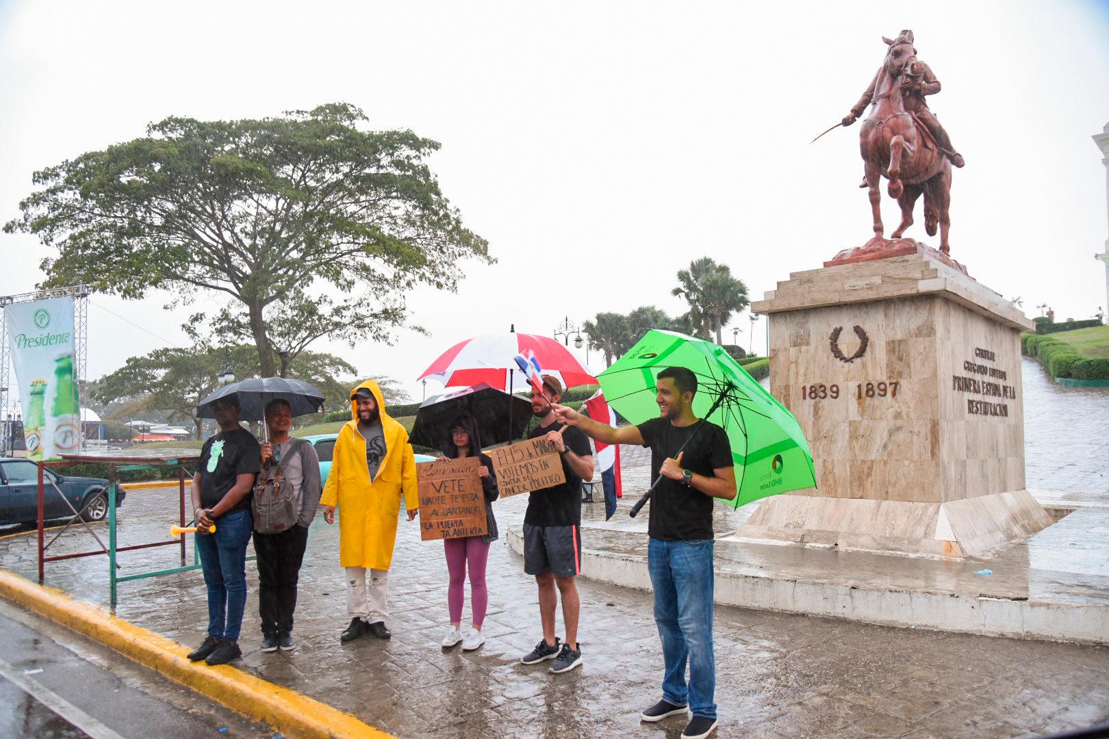 Los seis manifestantes, bajo sus paraguas para protegerse de la lluvia, cuestionaron que a 17 días del fracaso electoral aún no han dado a conocer quiénes son los responsables de sabotear el proceso.