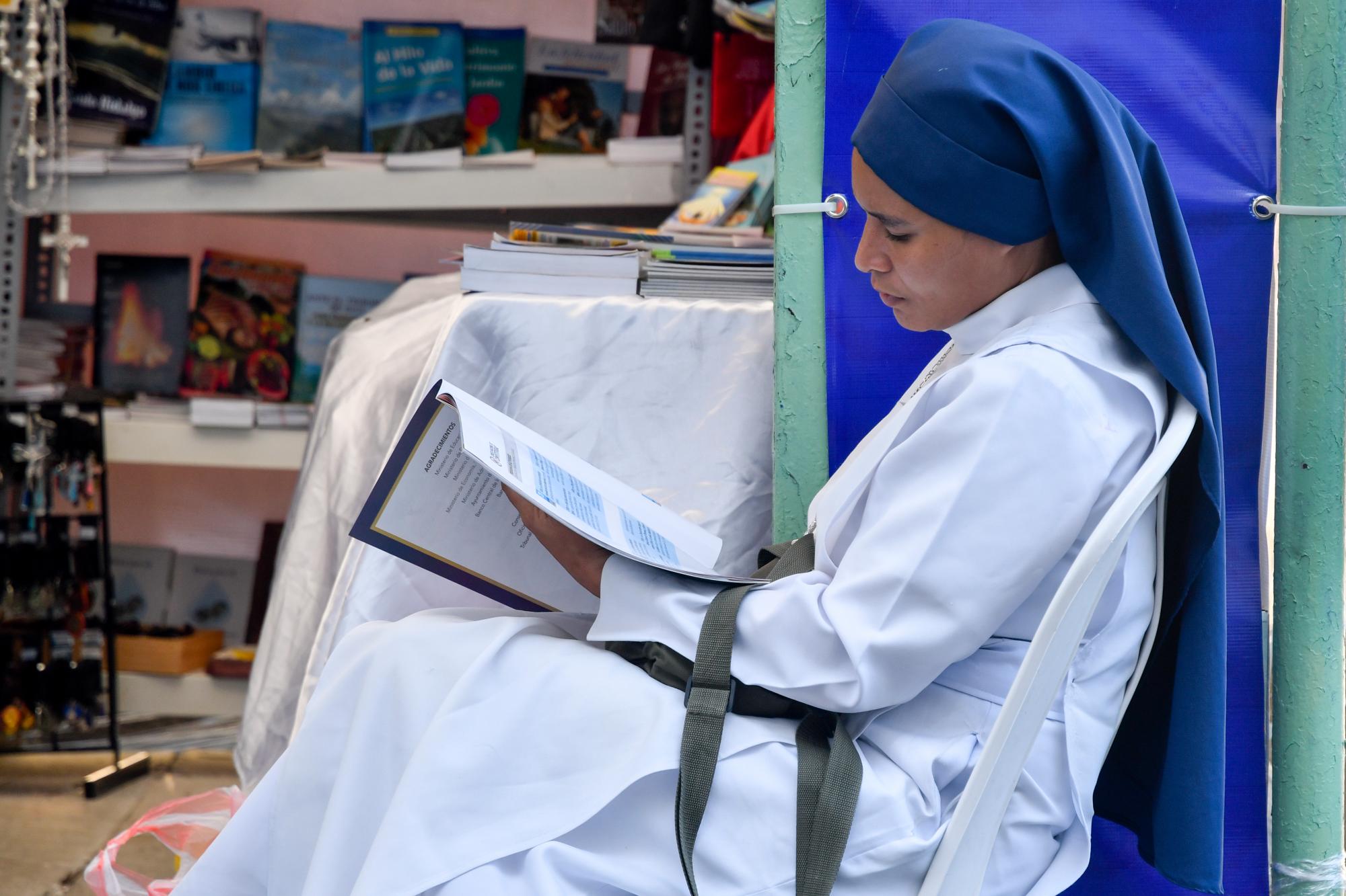 Mujer lee el programa de la feria en una librería cristiana