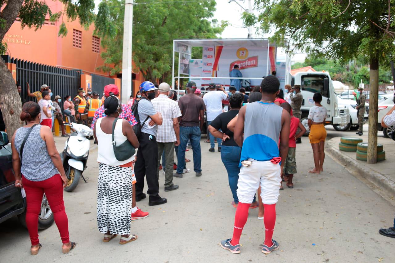 Personas hacen fila para recibir donaciones por presentar su tarjeta de que se vacunaron contra el COVID-19. Fuente externa