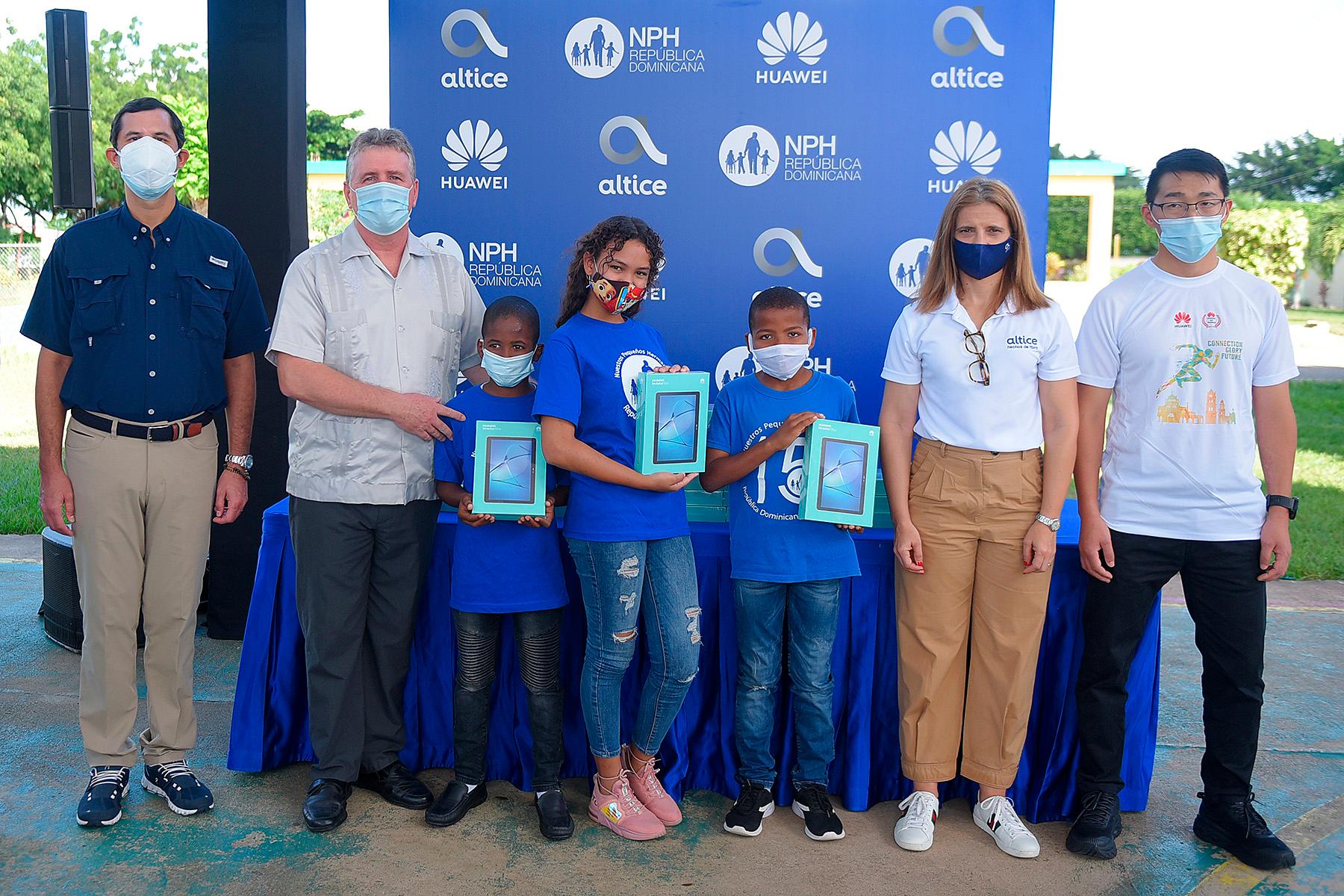 Niños del centro Nuestros Pequeños Hermanos reciben tabletas, de la mano de Altice Dominicana y Huawei, en compañía de directivos de la institución, ubicada en la ciudad de San Pedro de Macorís.