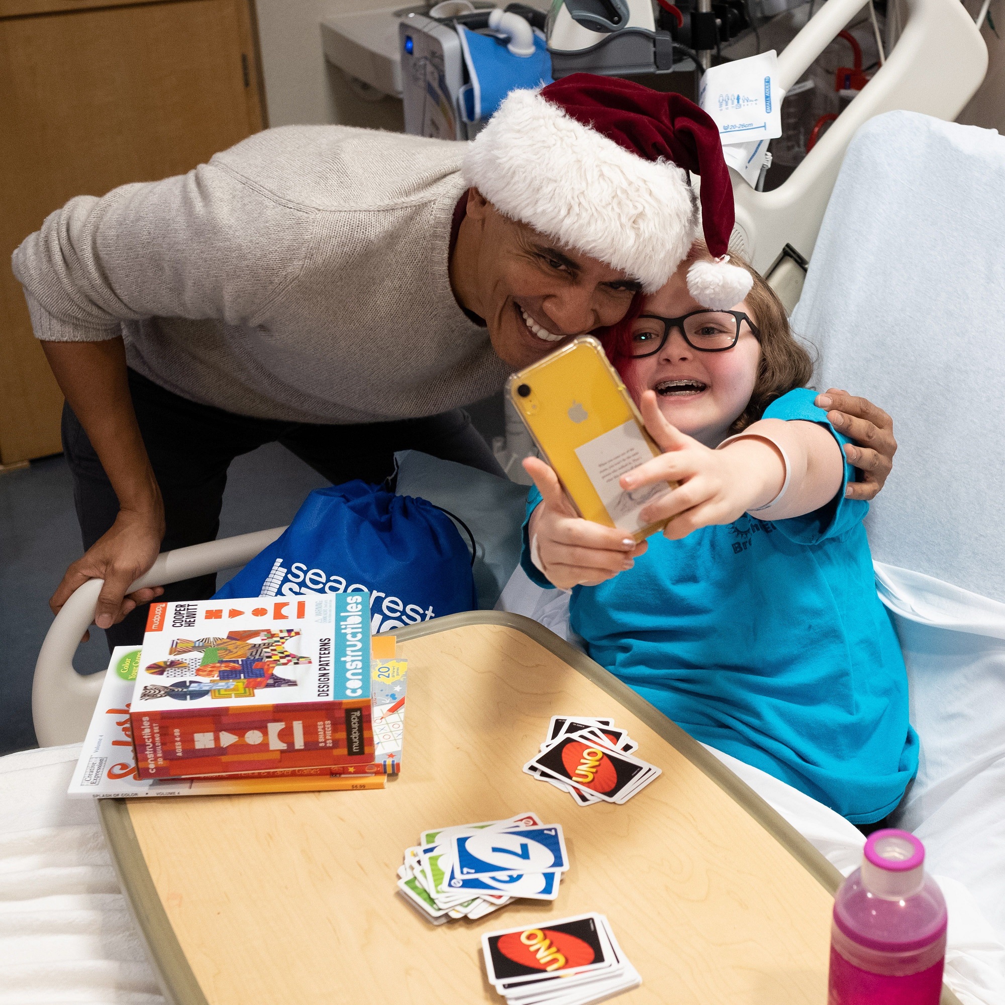 El expresidente de EE.UU. Barack Obama mientras posa para un selfi con una de las pequeñas pacientes mientras reparte regalos entre los niños ingresados en el hospital infantil Children's National Medical Center de Washington DC (EE.UU.).