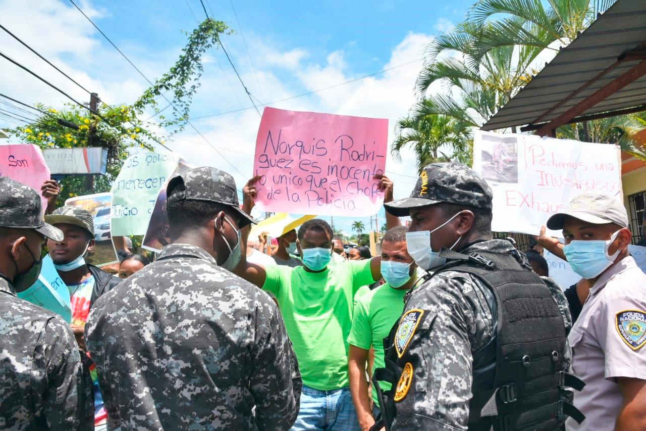 Parientes de policías portan pancartas antes de leerse el dictamen que los envía a prisión.
