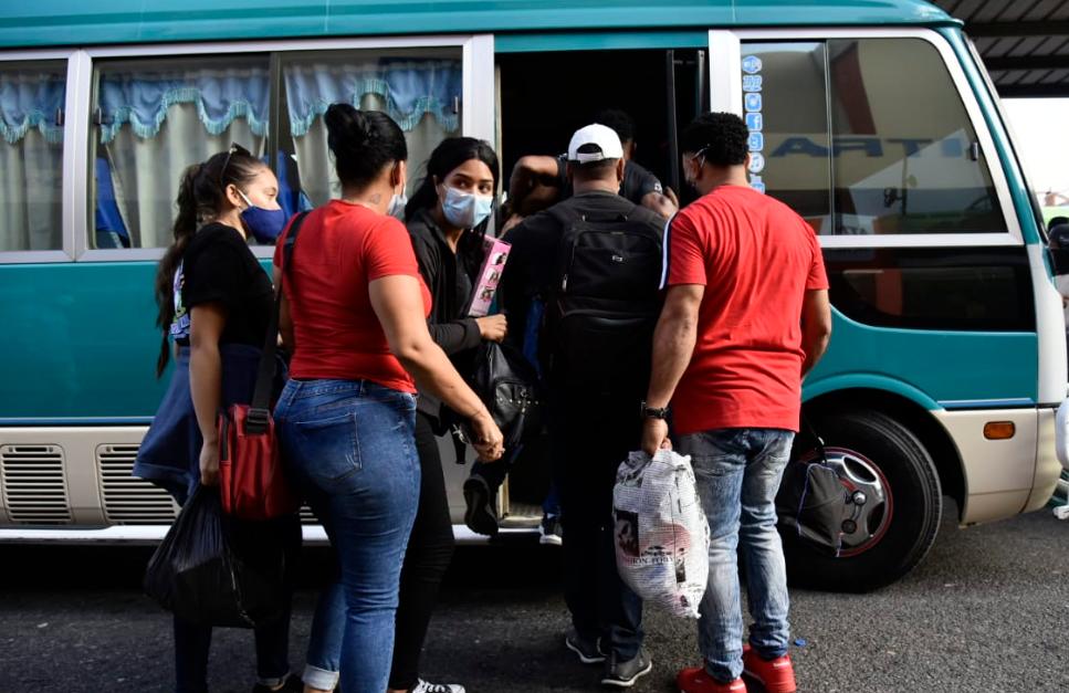 Pasajeros abordan una guagua hacia el Cibao. 