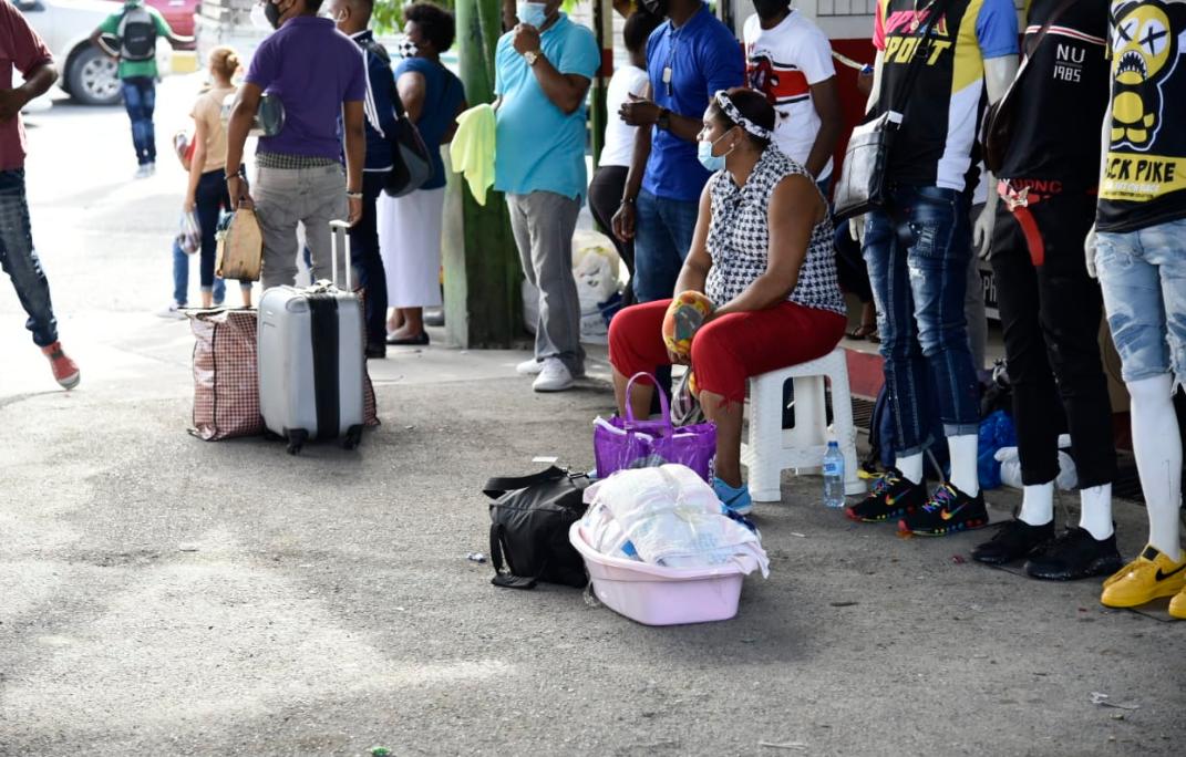 Personas esperan los vehículos de los partidos para viajar al sur.