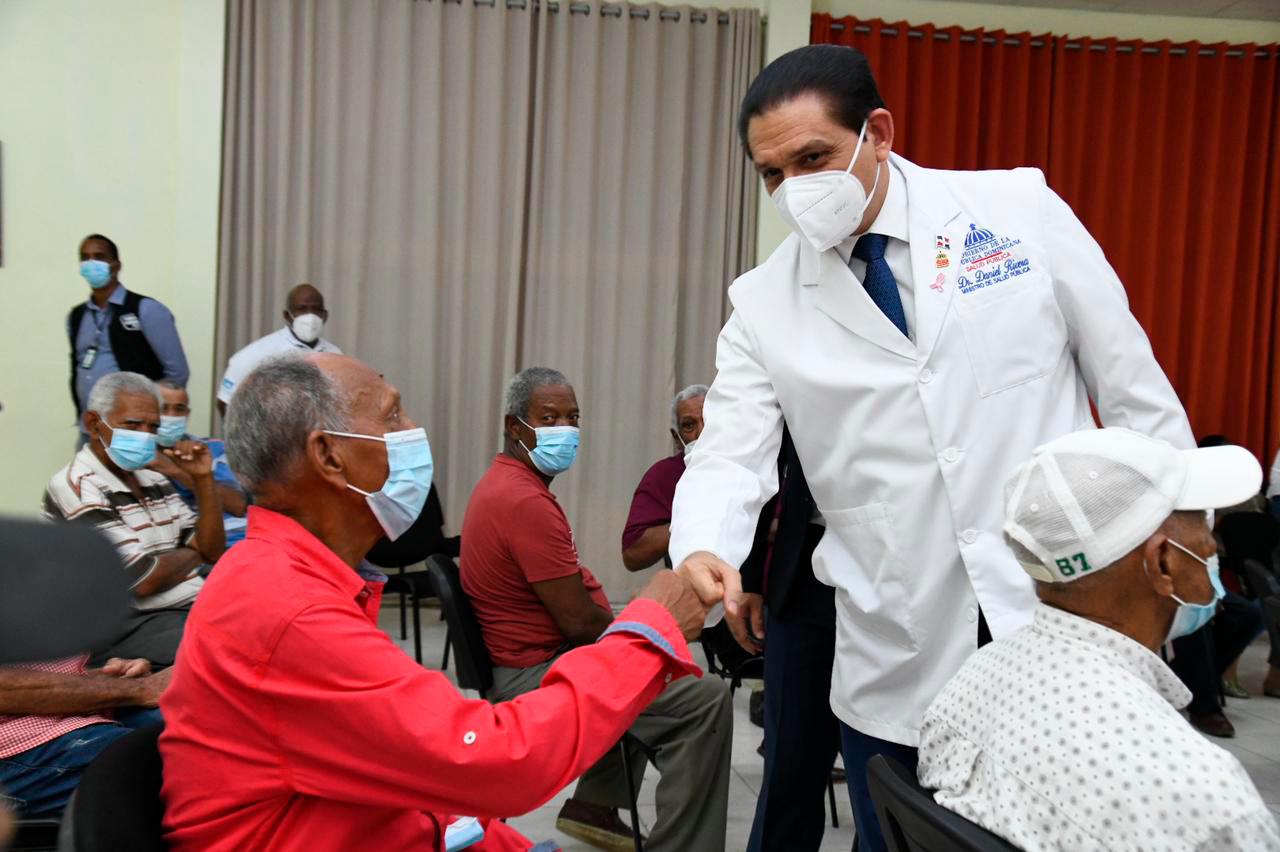 El ministro Daniel Rivera saluda uno de los adultos mayores de San Fernando de Montecristi.