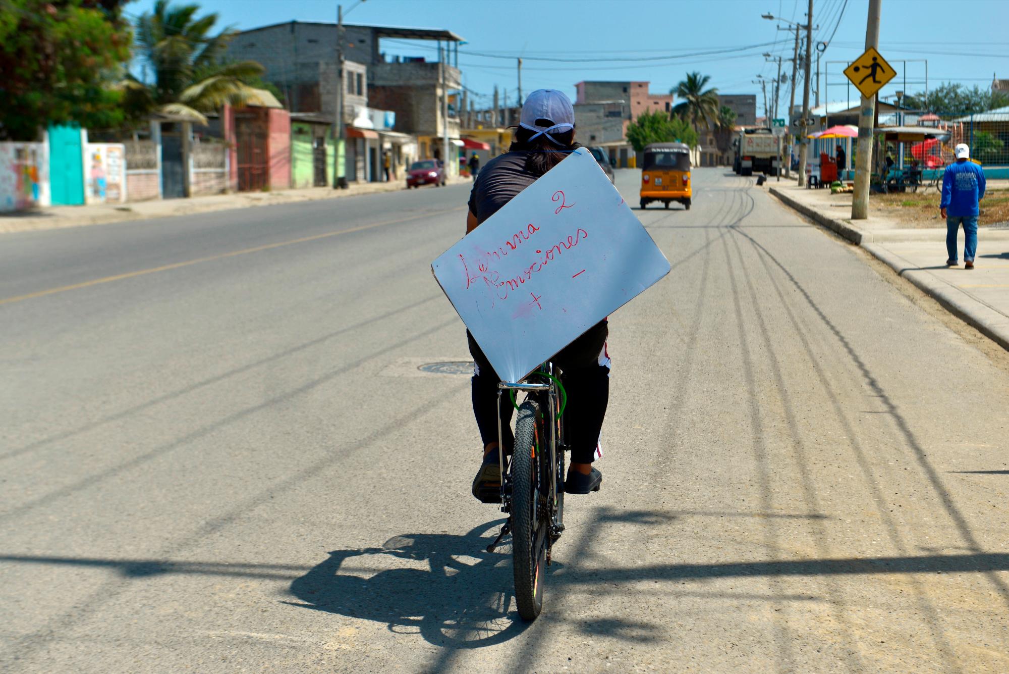 La profesora Carolina Espinoza se dirige en bicicleta a visitar a uno de sus alumnos este jueves, en Playas de Villamil (Ecuador).