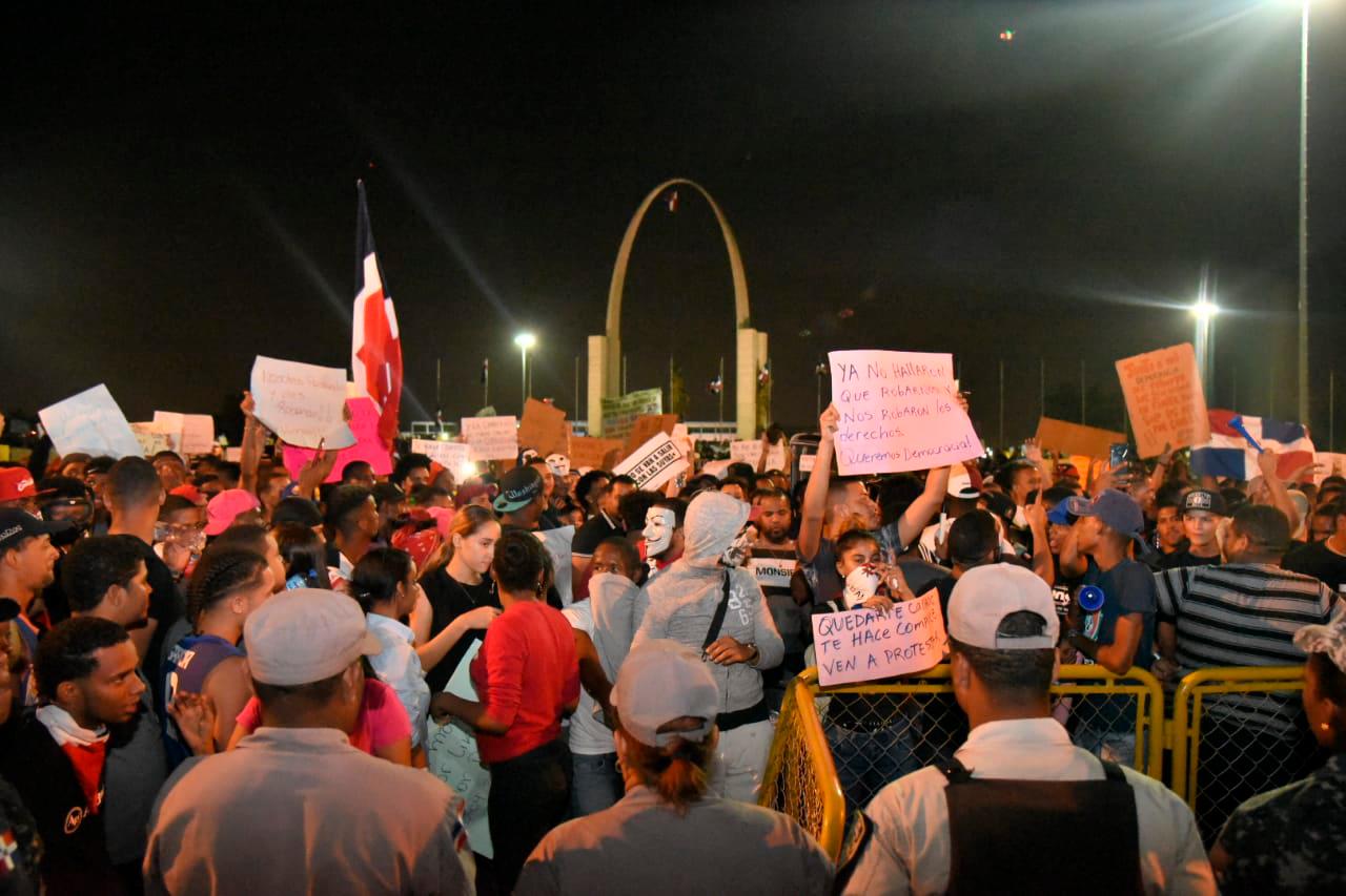 Jóvenes levantan pancartas desde la Plaza de la Bandera. 