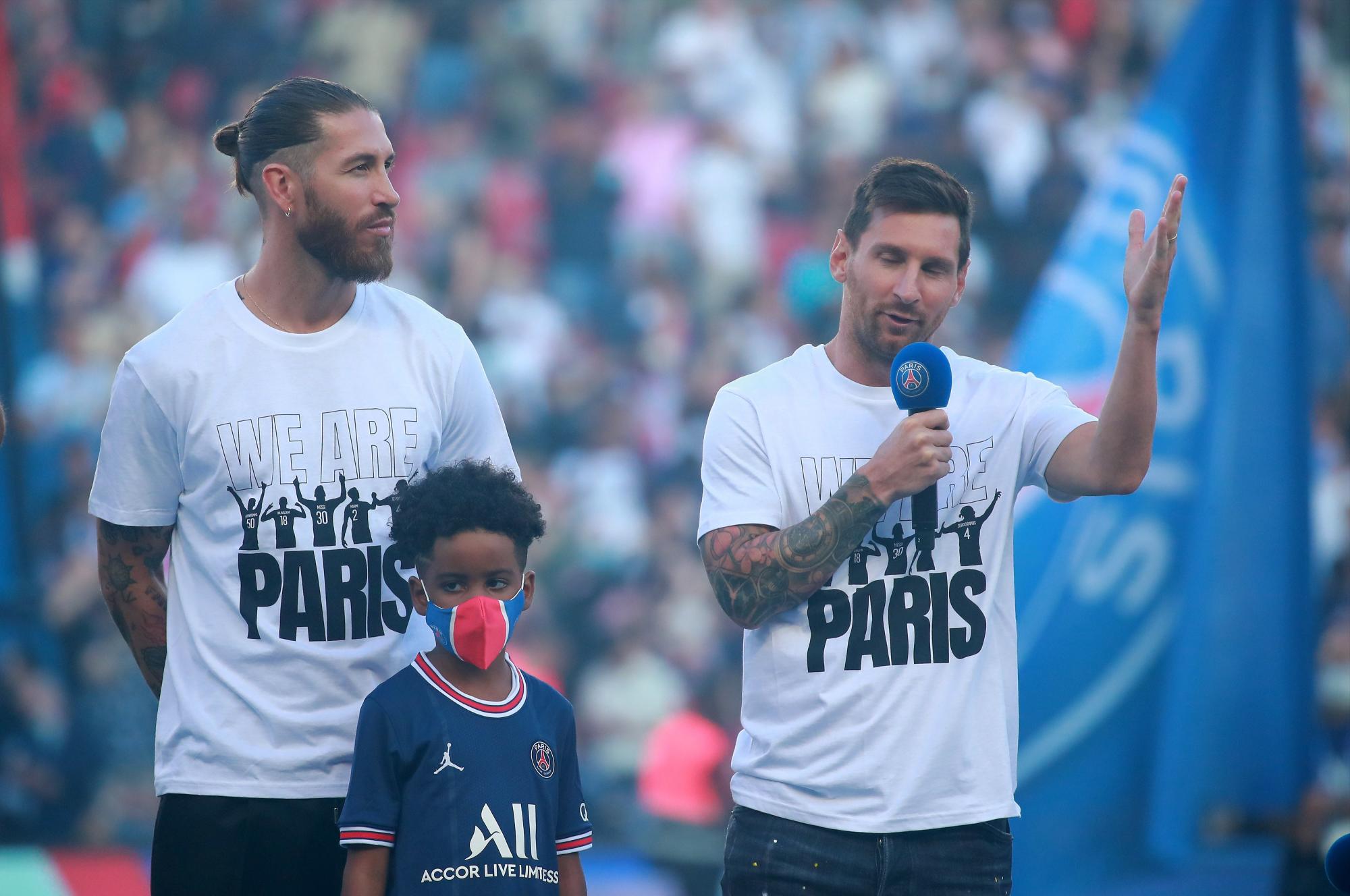 Los nuevos fichajes del Paris Saint-Germain Lionel Messi (derecha) y Sergio Ramos saludan a sus aficionados durante su presentación en el descanso del partido de fútbol de la Ligue 1 francesa entre Paris Saint Germain y Estrasburgo en el Parc des Princes estadio en París, Francia, 14 de agosto de 2021. (EFE/EPA/Christophe Petit Tesson)