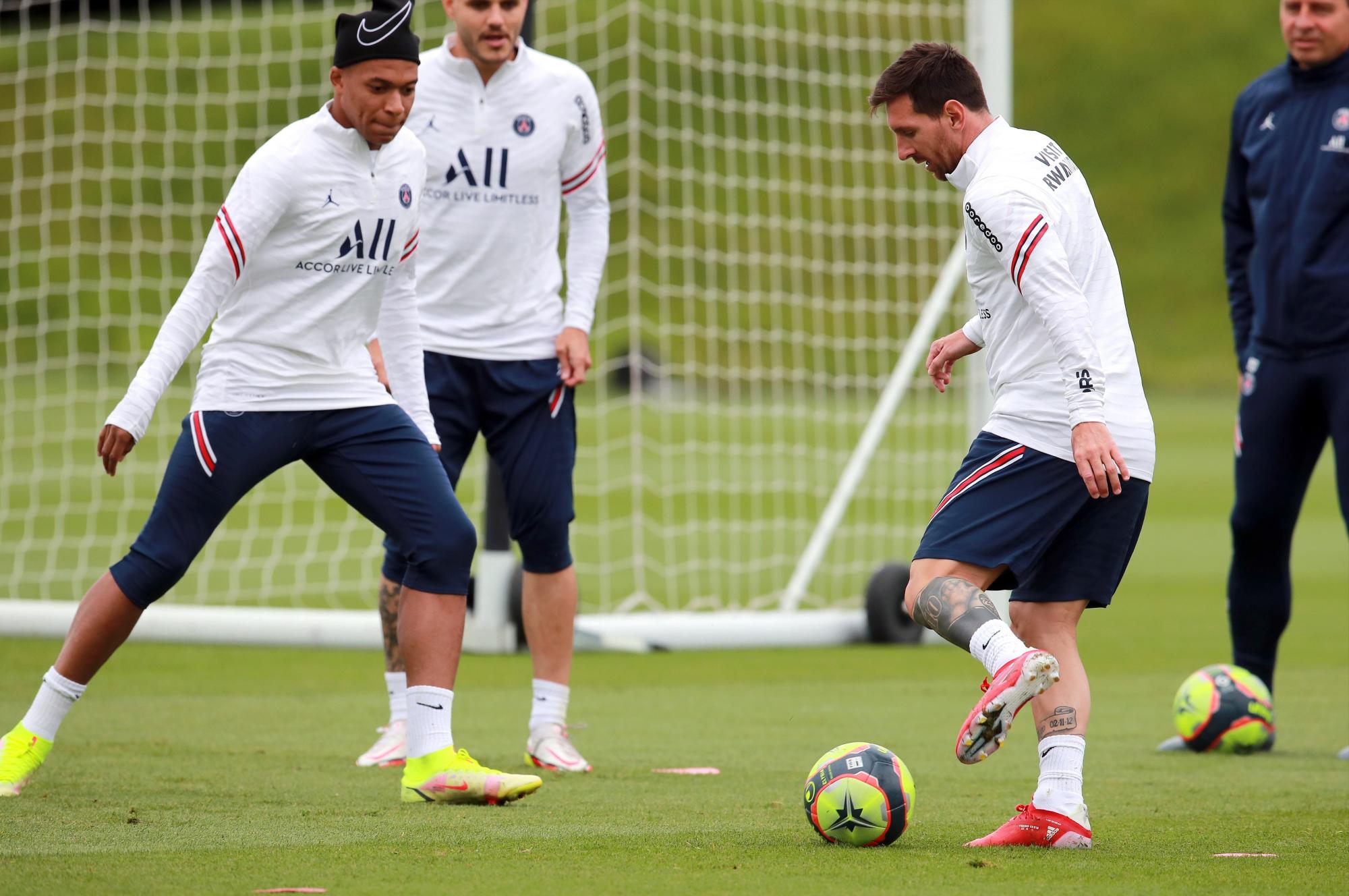 Kylian Mbappé (izq.) Y Lionel Messi (der.) del Paris Saint Germain asisten a una sesión de entrenamiento en el complejo deportivo Camp des Loges cerca de París, Francia, el 19 de agosto de 2021. (EFE/EPA/Christophe Petit Tesson)