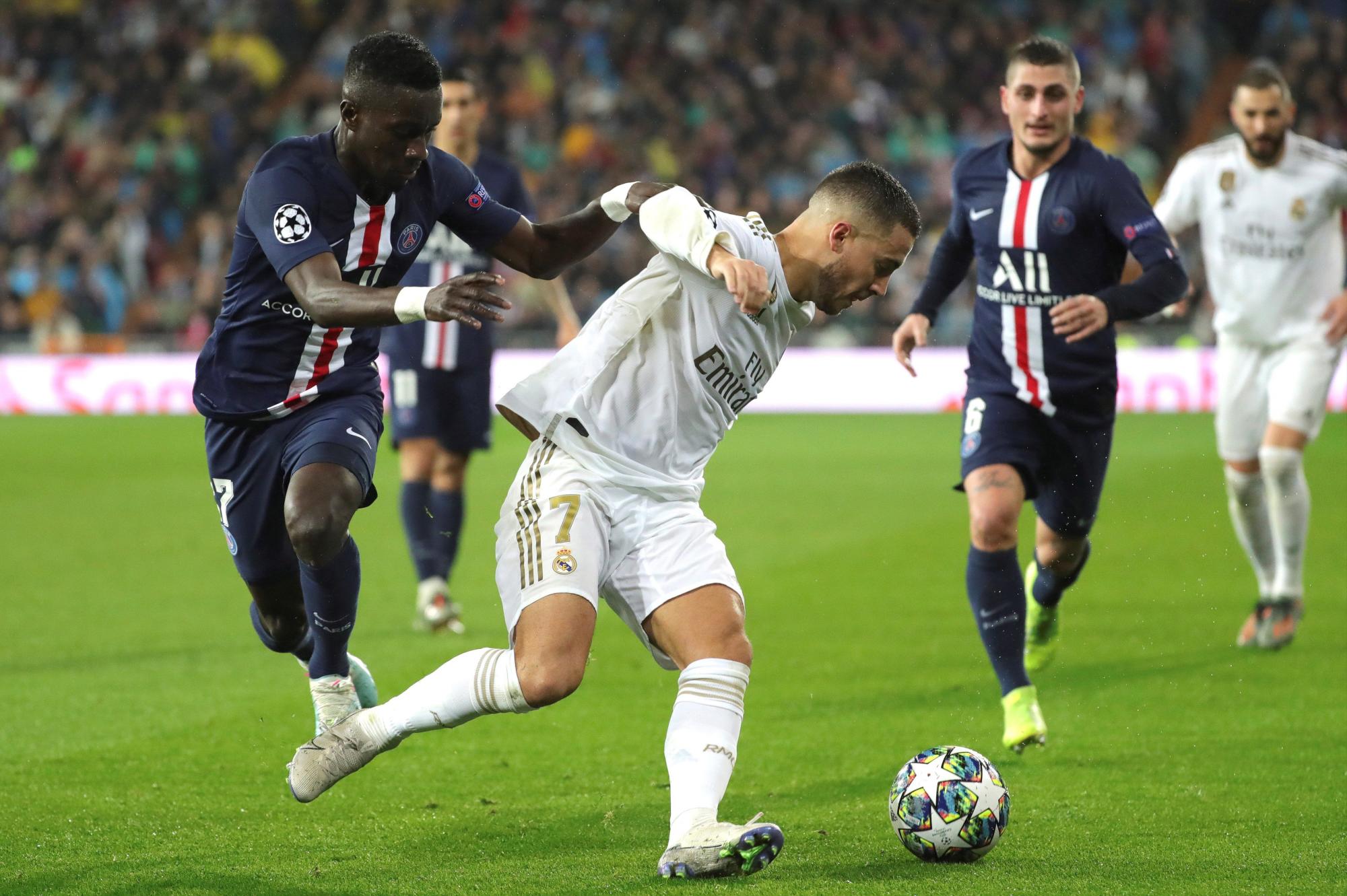 El centrocampista belga del Real Madrid Eden Hazard rodeado de jugadores del Paris Saint-Germain.