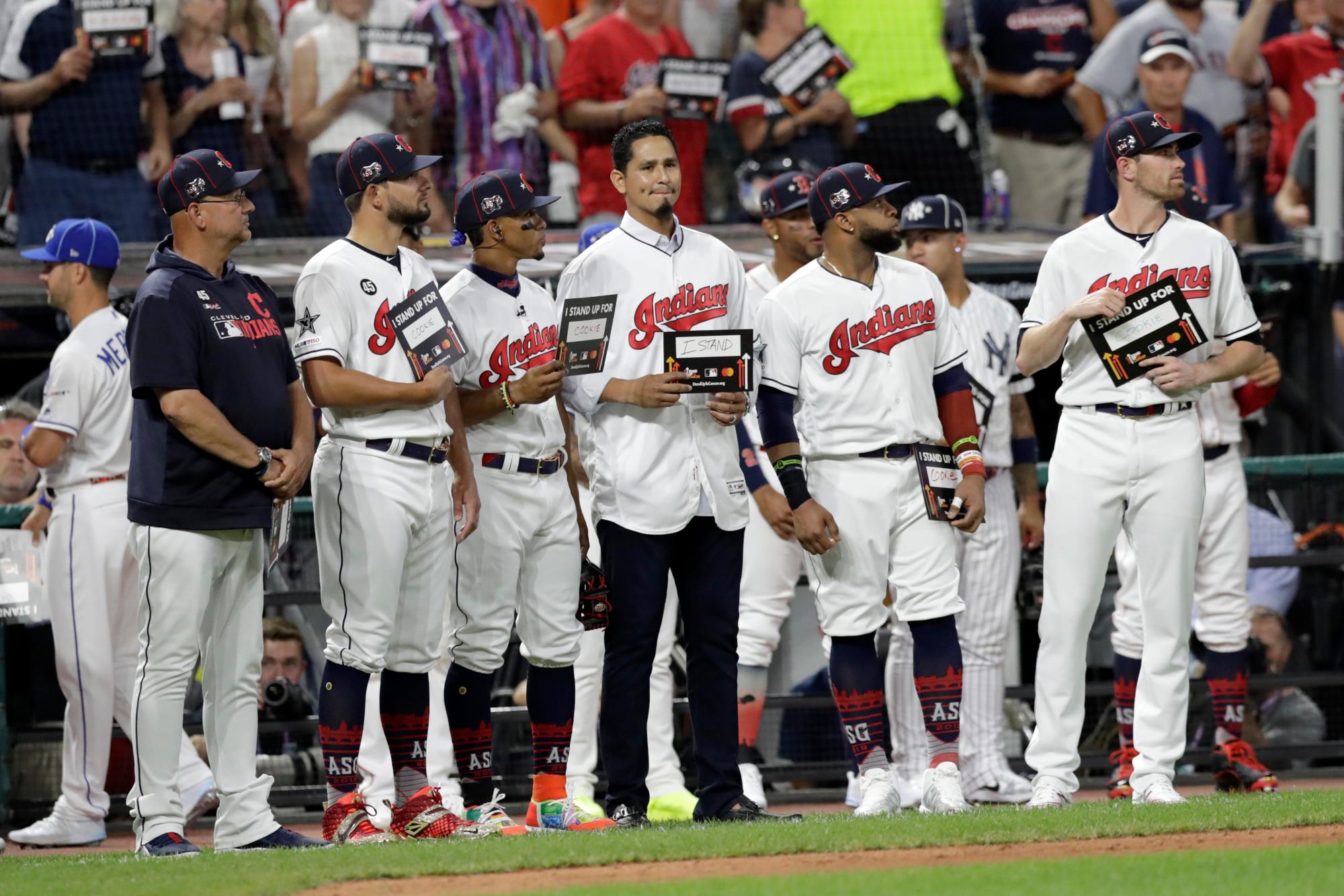 El venezolano Carlos Carrasco (centro) muestra un letrero junto con sus compañeros de los Indios de Cleveland durante el Juego de Estrellas, el martes 9 de julio de 2019. Carrasco, a quien se diagnosticó recién una forma de leucemia, recibió muestras de solidaridad en el encuentro, como parte de la capaña Stand Up to Cancer.