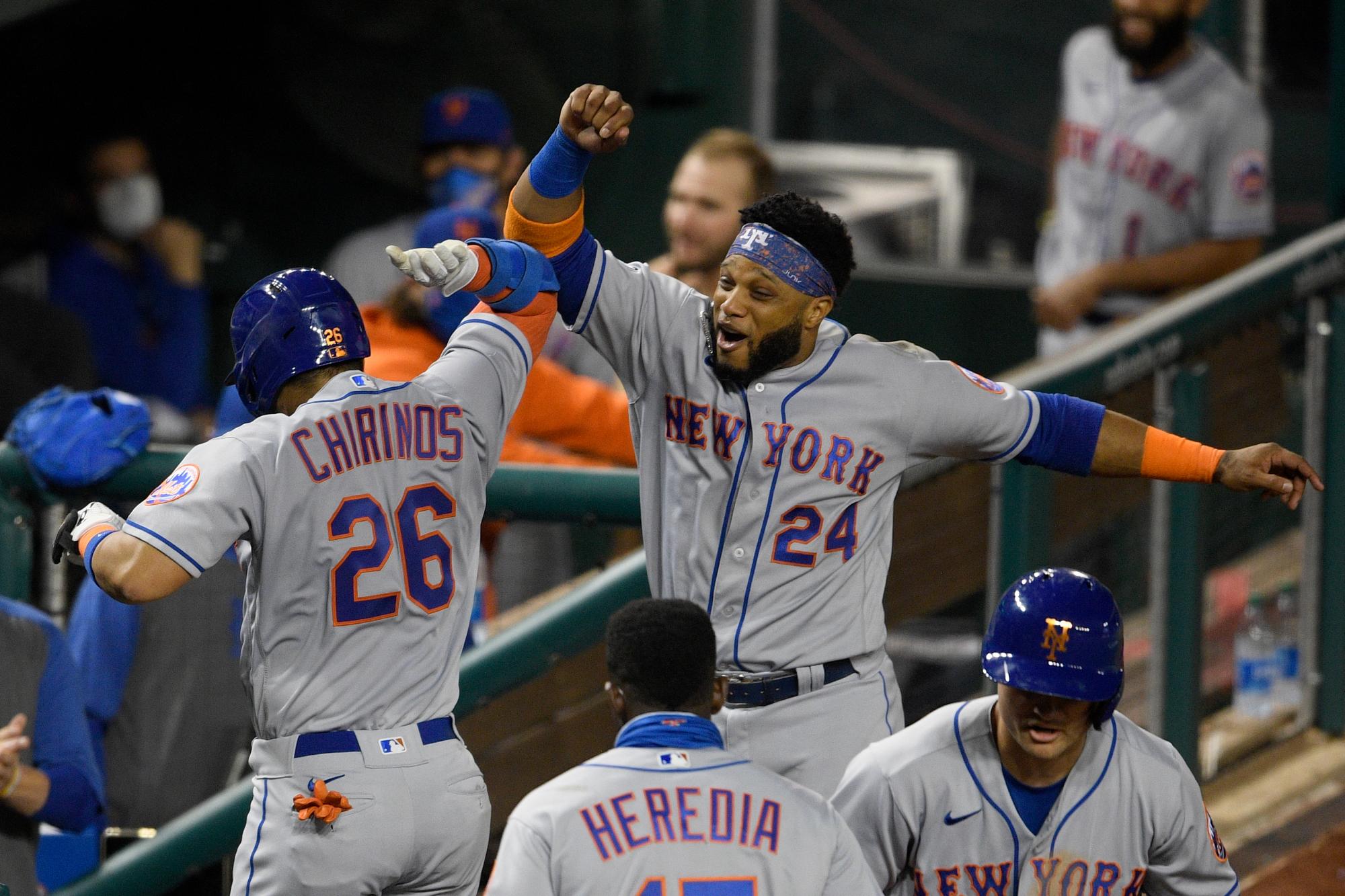 Robinson Chirinos (26) de los Mets de Nueva York celebra su jonrón de dos carreras con Robinson Cano (24) durante la quinta entrada del juego de béisbol del equipo contra los Nacionales de Washington, el jueves 24 de septiembre de 2020 en Washington. 