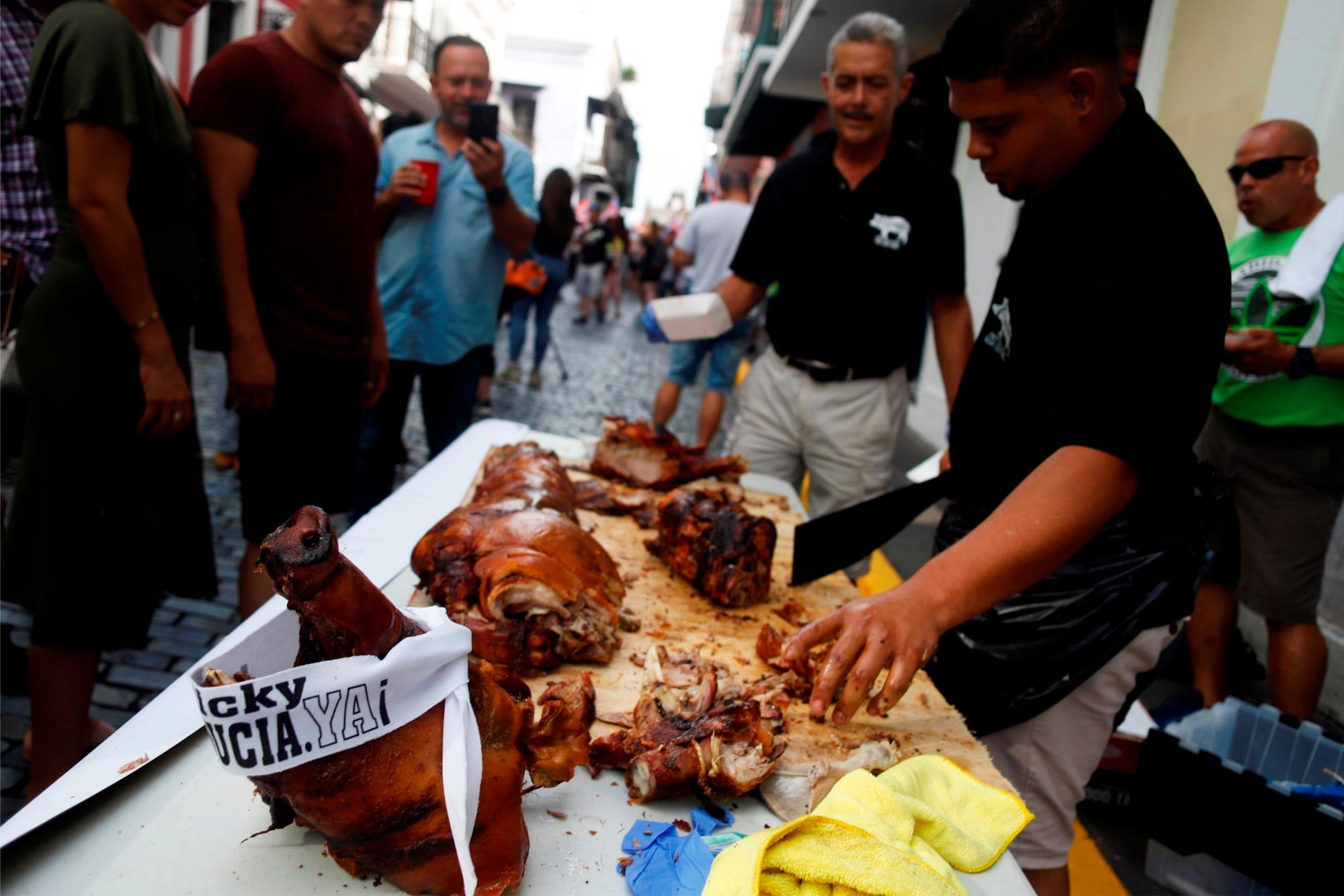 Vecinos de San Juan (Puerto Rico) celebran este viernes la renuncia efectiva del exgobernador Ricardo Rosselló con un puerco asado.