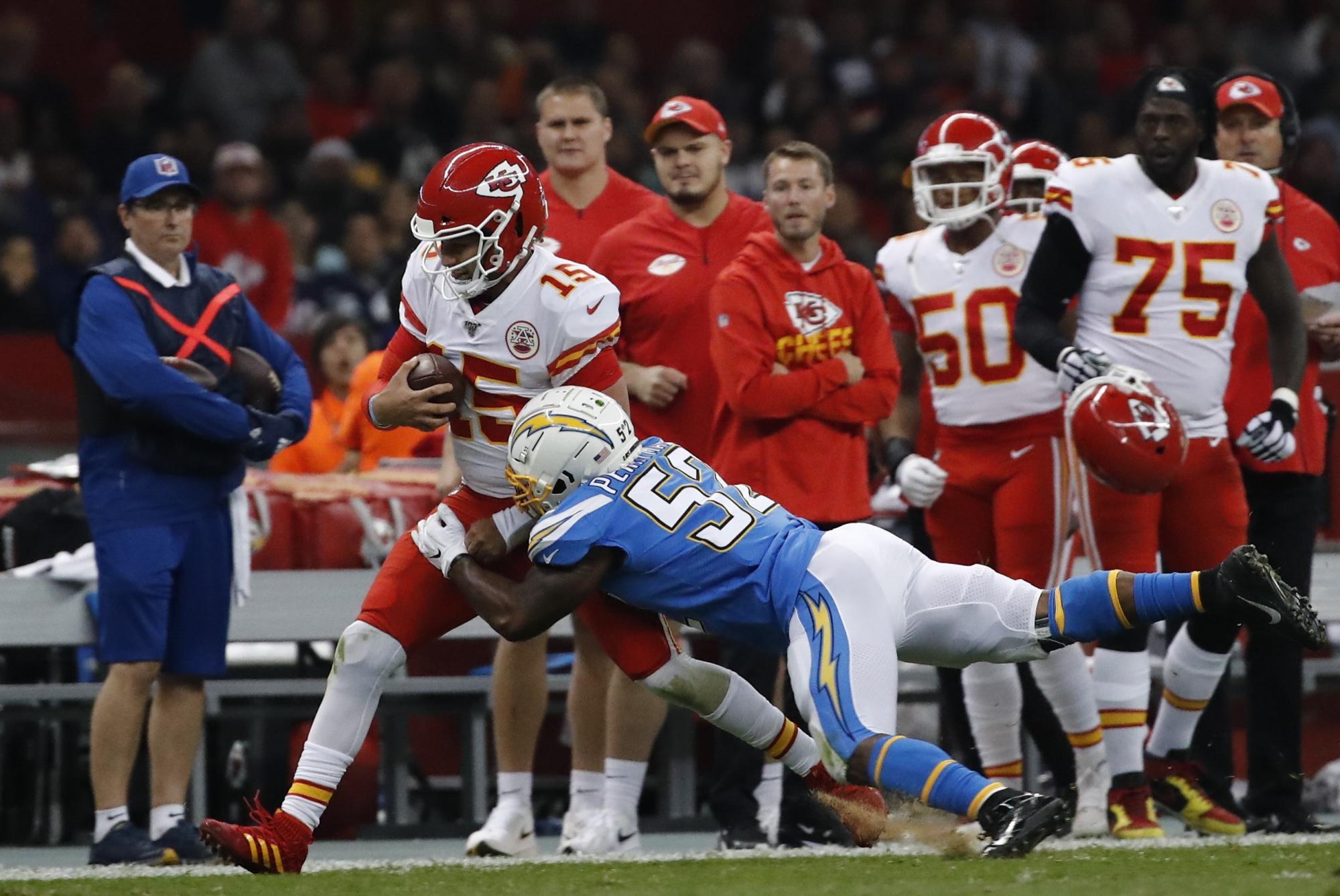 A Patrick Mahomes (i) de los Chiefs, lo intenta detener en el partido de este lunes, durante el juego de la NFL entre San Diego Chargers y Kansas.