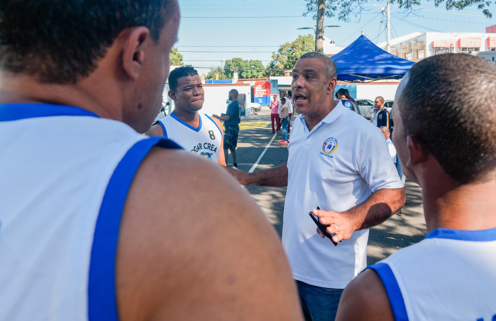 El supervisor Igor Peguero coordina con el equipo antes de iniciar el juego. 