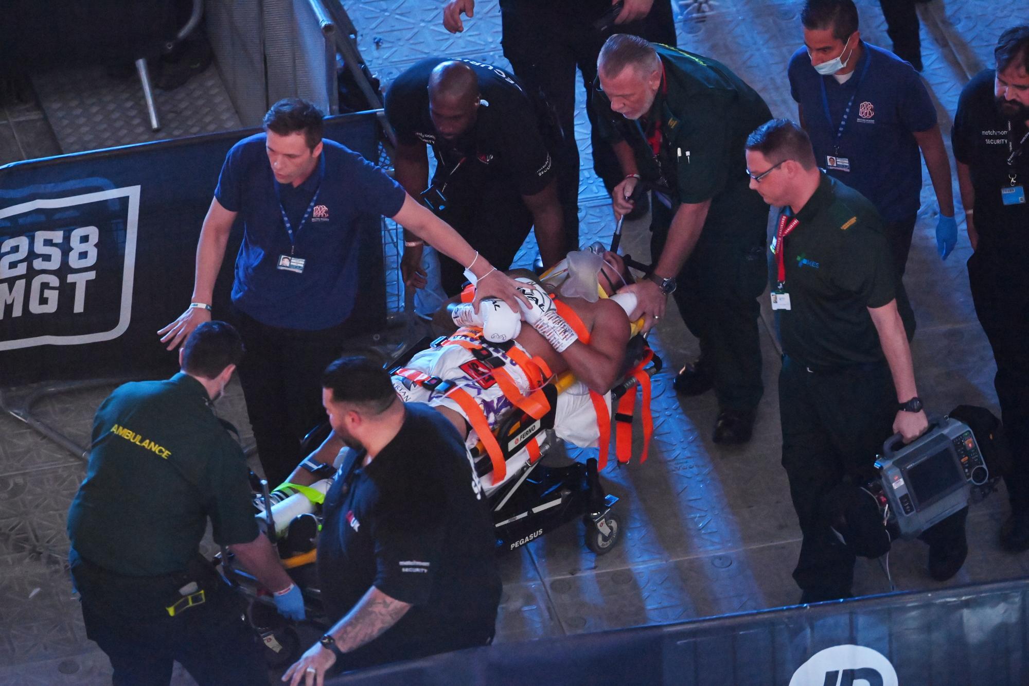 Paramédicos y personal médico ensanchan al dominicano Lenin Castillo tras perder su combate por el título de peso semipesado en el Tottenham Hotspur Stadium de Londres, Reino Unido, el 25 de septiembre de 2021. (EFE/EPA/Neil Hall)
