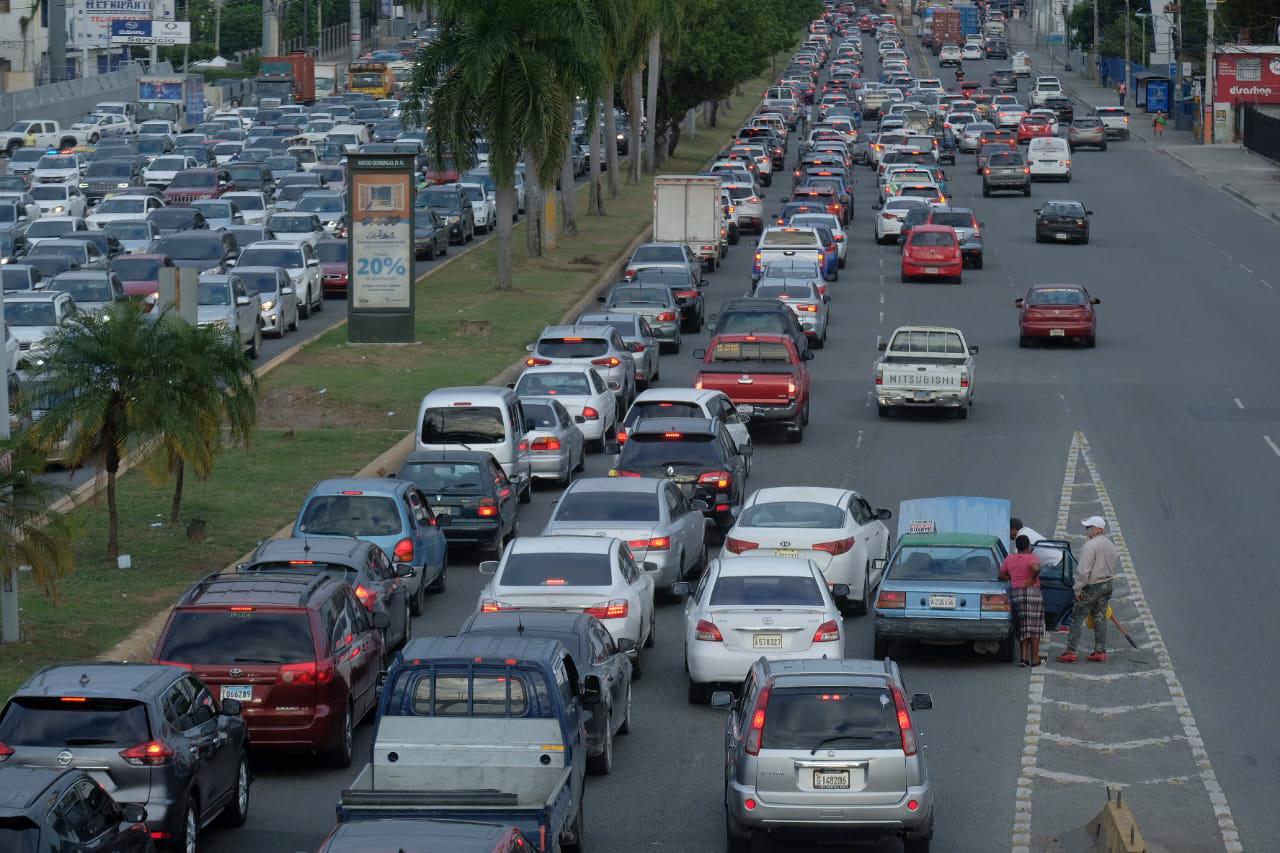 En esa imagen de observa un carro público averiado junto a decenas de vehículos durante el tapón en el toque de queda en la avenida John F. Kennedy.