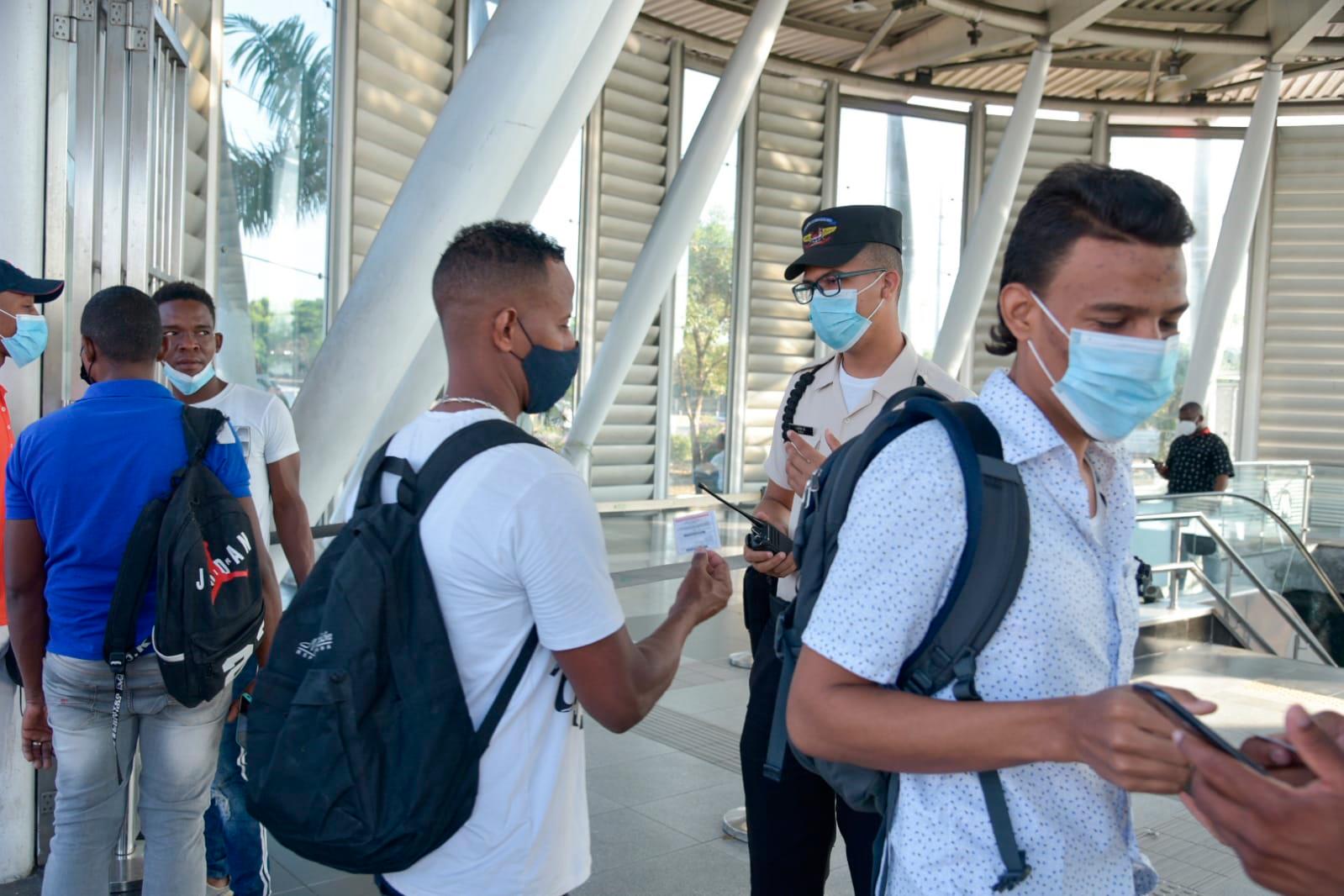 Los usuarios del Metro de Santo Domingo muestran sus tarjetas de vacunación a los agentes del Cesmet en la estación María Montez en el kilómetro 9 de la autopista Duarte.