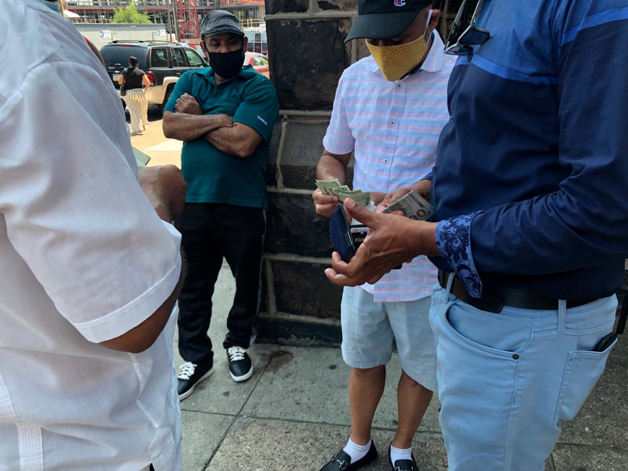 Delegados de partidos presentan apuestas por los candidatos presidenciales frente al centro de votación Visitation Catholic School.