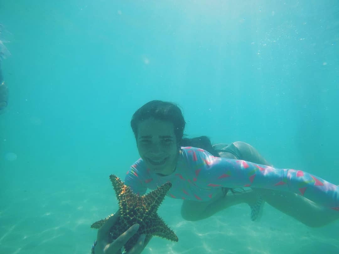 En la profundidad de la laguna la gente captura estrellas de mar.