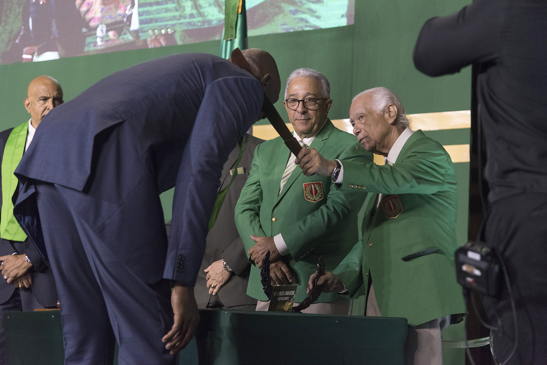 Por su estatura, Al Horford, padre tuvo que inclinarse lo suficiente para que Carlos Lamarche pudiera imponerle el machete en el 52 ceremonial el domingo 11 de noviembre de 2018 en el Pabellón de la Fama del Deporte Dominicano.