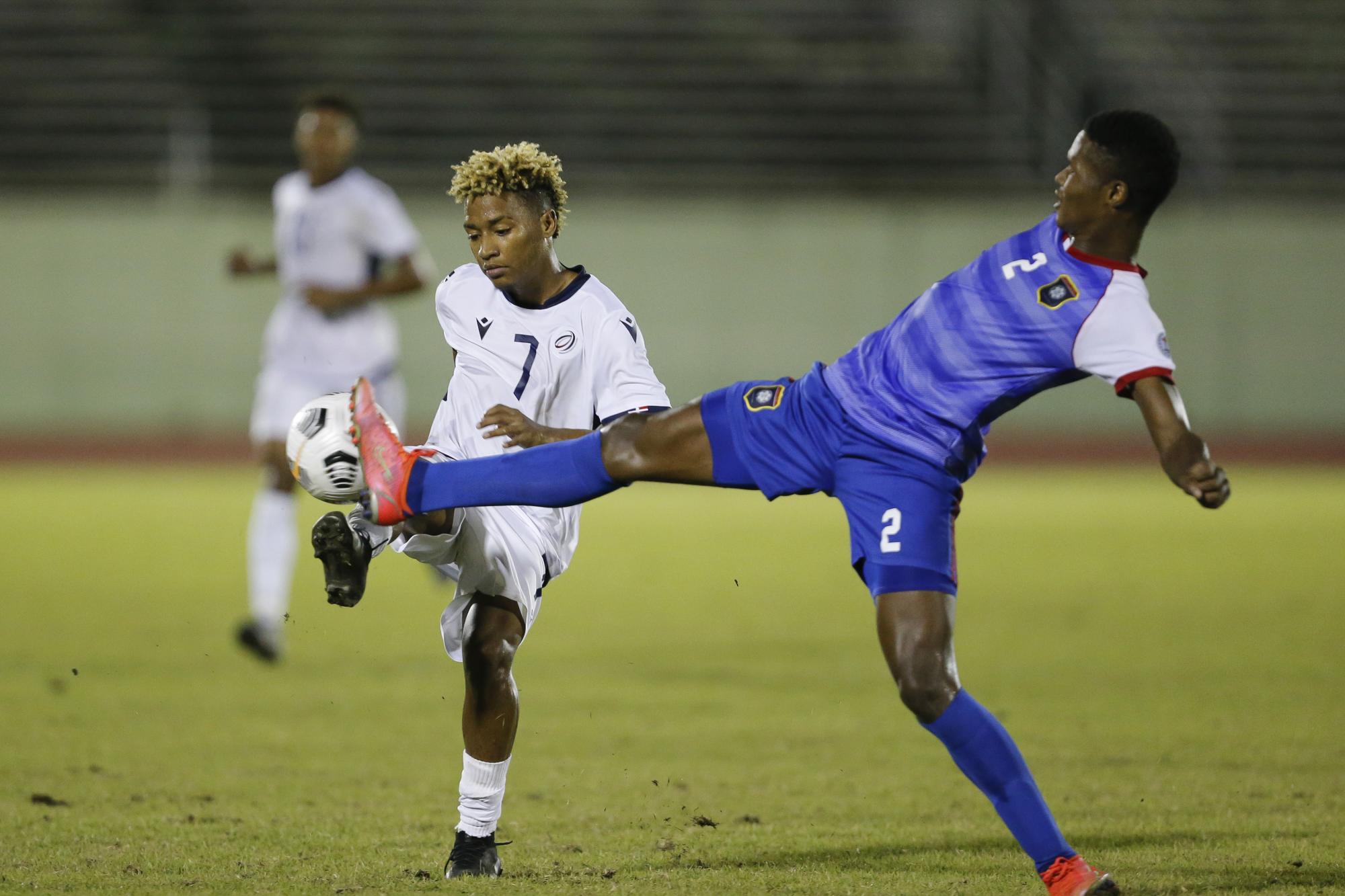 Bryan More (DOM) y Calvin Reid luchan por el balón durante el compromiso que enfrentó a Dominicana y Belice por las eliminatorias del Mundial de Indonesia 2023. (Foto: Nelson Pulido / CONCACAF)