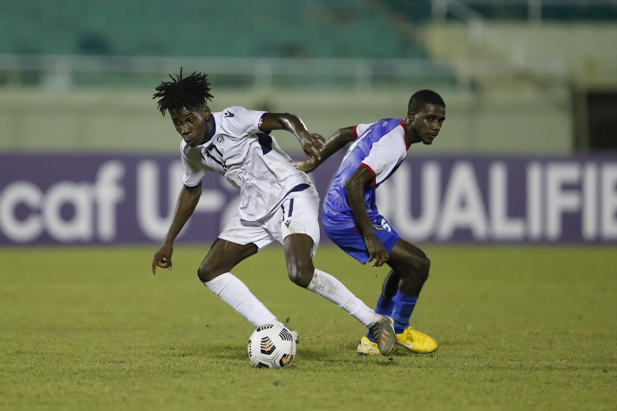 Jason Yambatis controla gana el duelo ante el defensor Zion Ramos, durante el compromiso que enfrentó a Belice y Dominicana, por las eliminatorias del Mundial Sub-20 Indonesia 2023. (Foto: Nelson Pulido / CONCACAF)