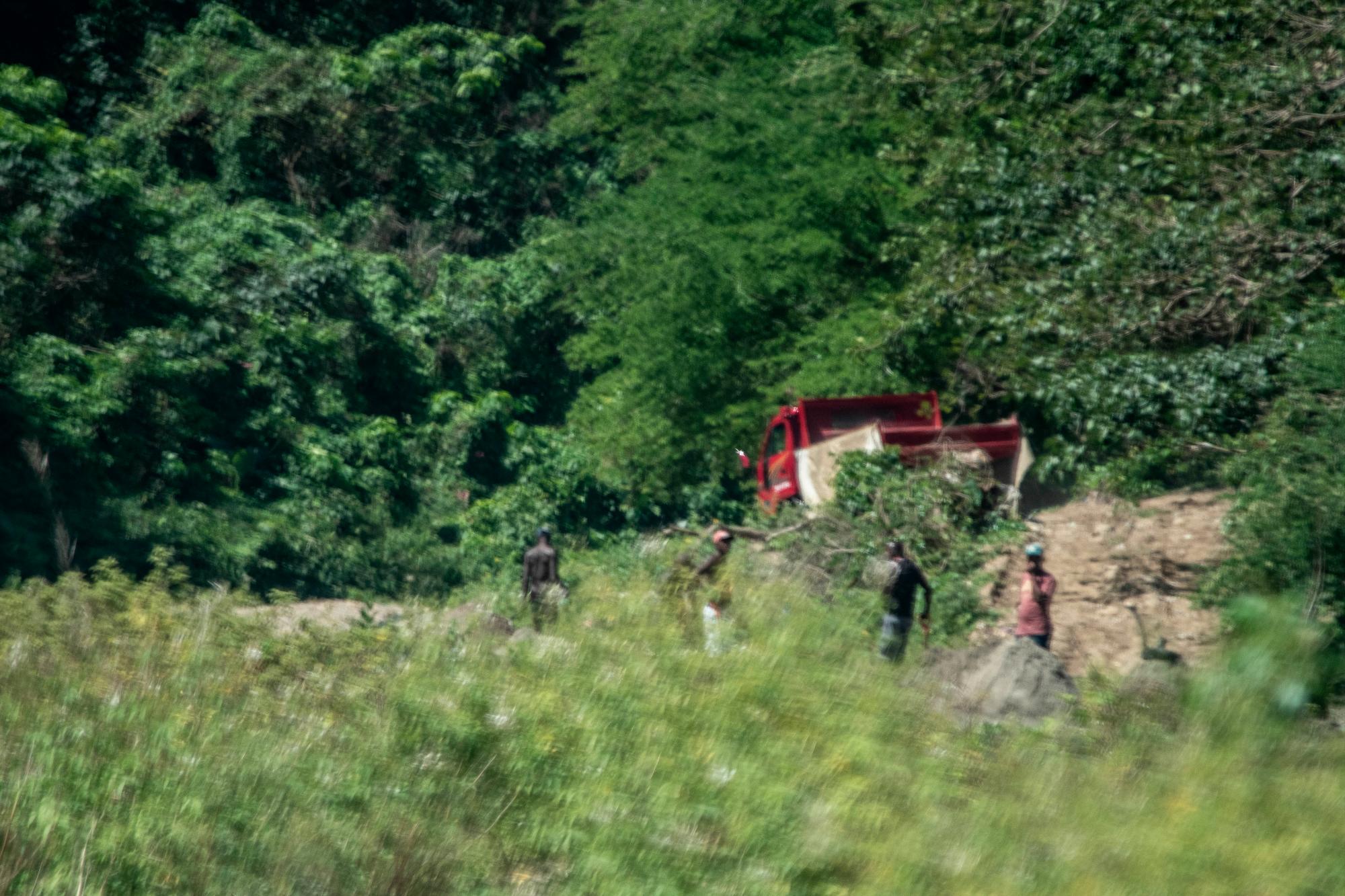 Un camión y los hombres que llenaban su cama se marchan de un punto del río Nigua tras avistar el vehículo en el que se transportaba el equipo de esta investigación, el 13 de marzo de 2019. Retornaron luego.