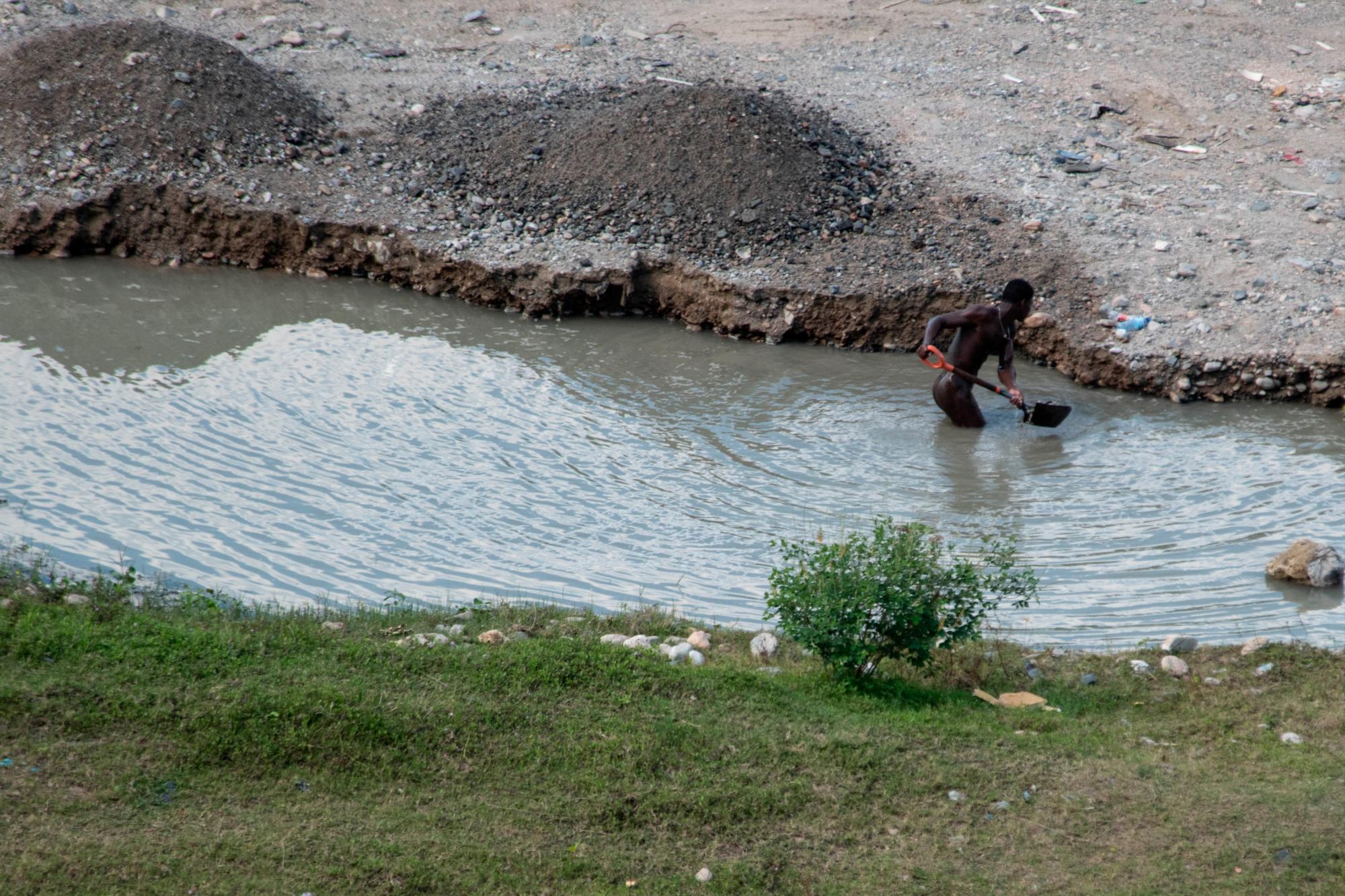 Un “hombre hormiga” extrae arena del río Nigua para posteriormente abastecer a un camión, el 13 de marzo de 2019.