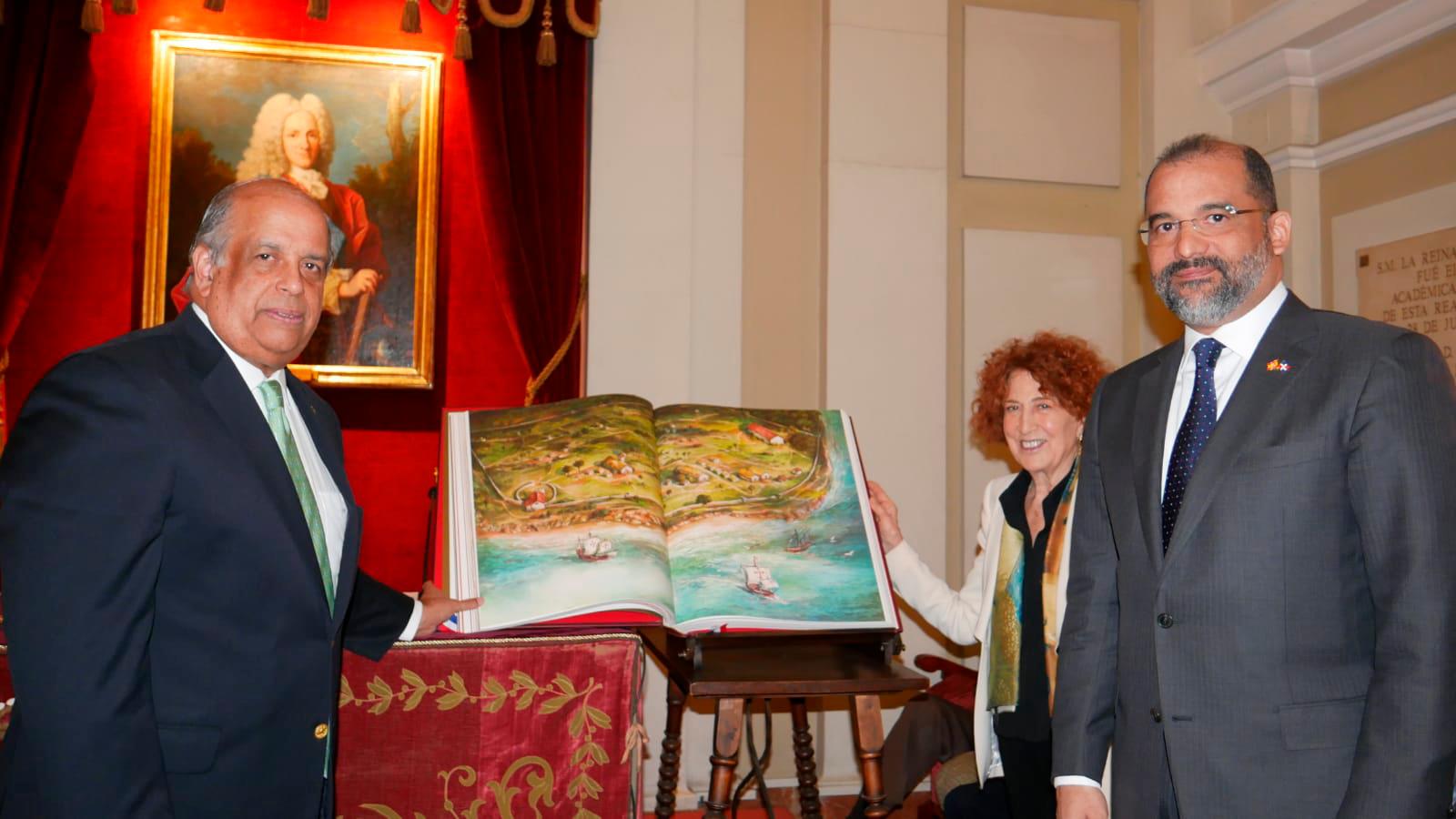 Juan Daniel Barcácel, Carmen Iglesias y el embajador dominicano ante España posan frente a la edición Códice de la Historia General del Pueblo Dominicano. 