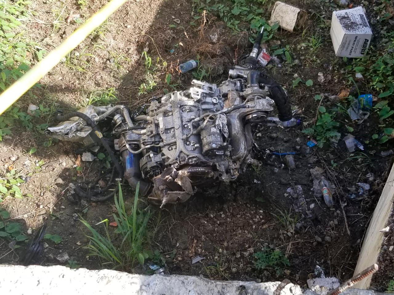 Las partes del vehículo se esparcieron varios metros del lugar del accidente. En la imagen el motor del carro.