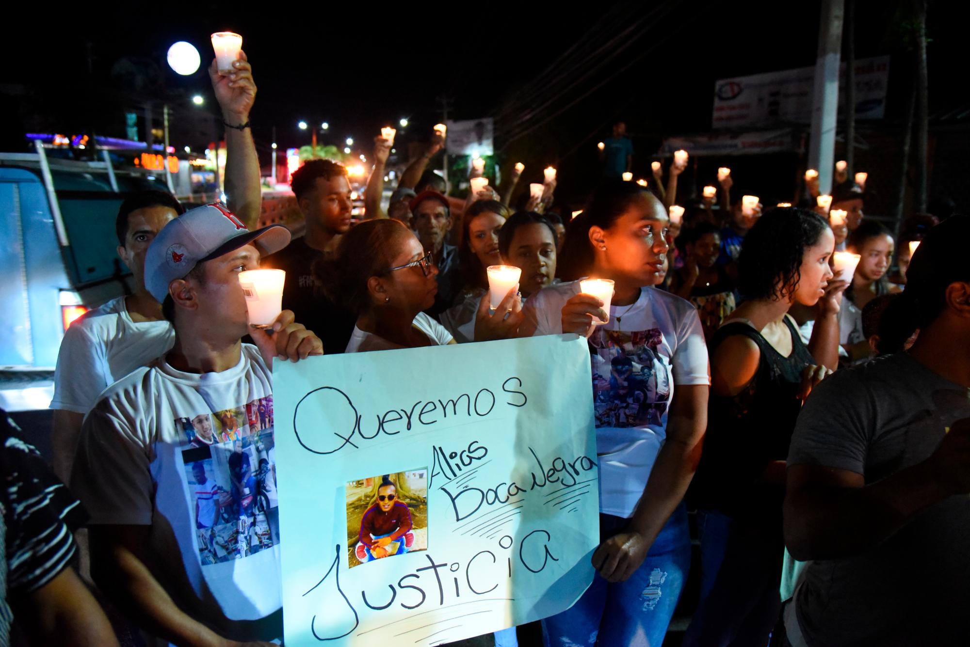 Familiares y amigos reunidos en el paso por la carretera Duarte, en la localidad La Culebra de Don Pedro, al este de Santiago, durante el encendido de velas. 
