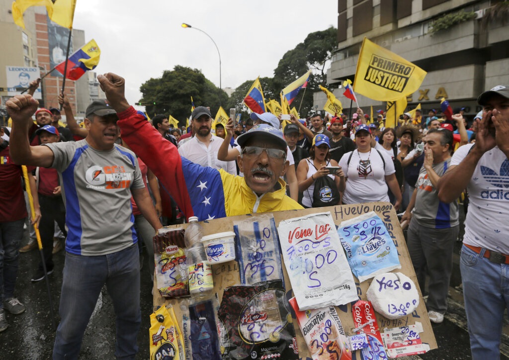 Un miembro de la oposición sostiene un cartel con los precios de los alimentos básicos durante una protesta contra el presidente de Venezuela, Nicolás Maduro, en Caracas, Venezuela, el miércoles 23 de enero de 2019. 
