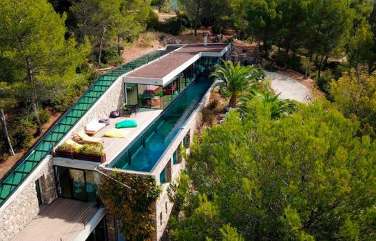 Una lujosa villa atravesada por una piscina transparente 