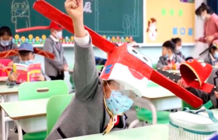 Alumnos chinos vuelven a clases usando sombreros de un metro de ancho para mantener distancia social