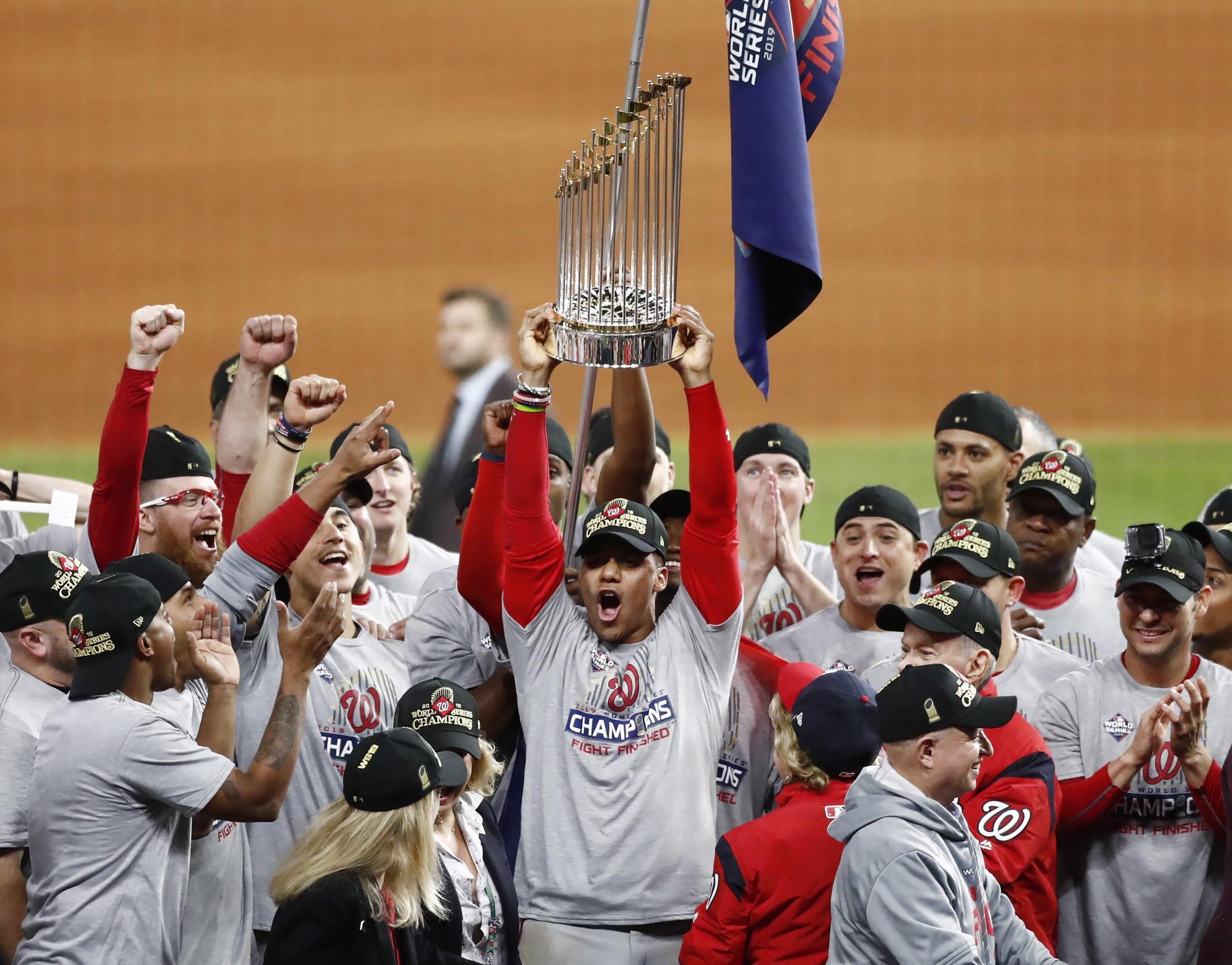 Juan Soto levanta la copa de campeón de los Nacionales de Washington que vencieron en siete partidos a los Astros de Houston. (EFE/Larry W. Smith)